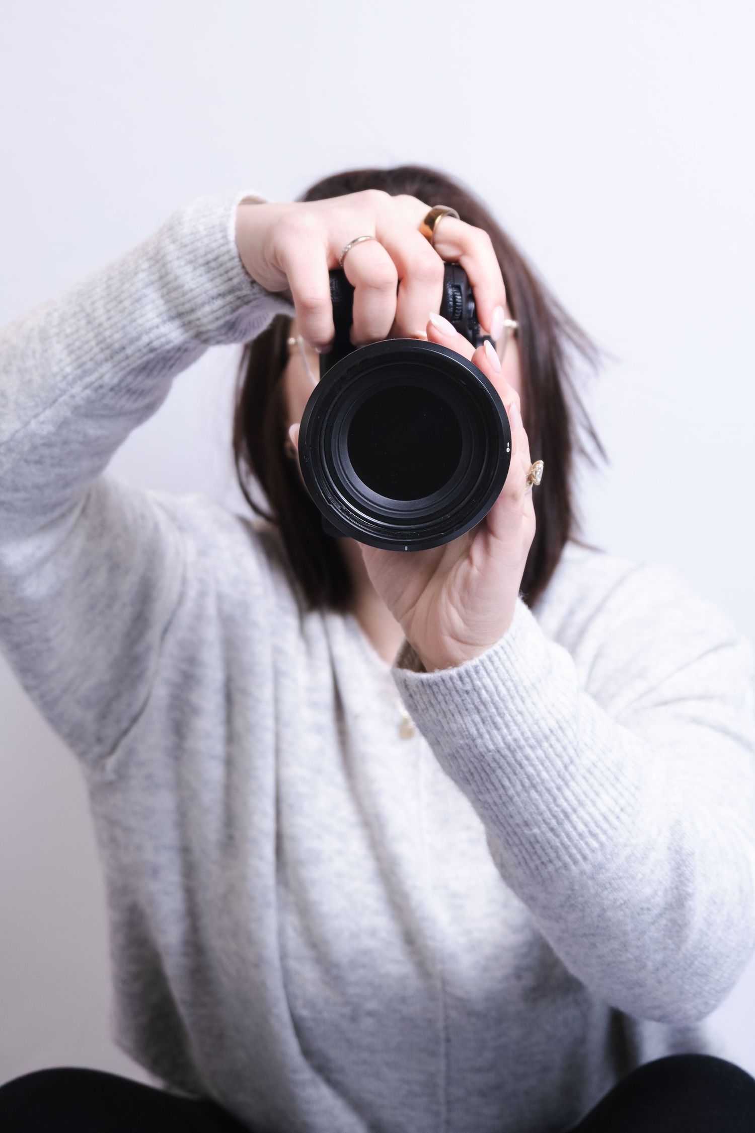 A series of photos showing hands holding a camera lens against a white background.