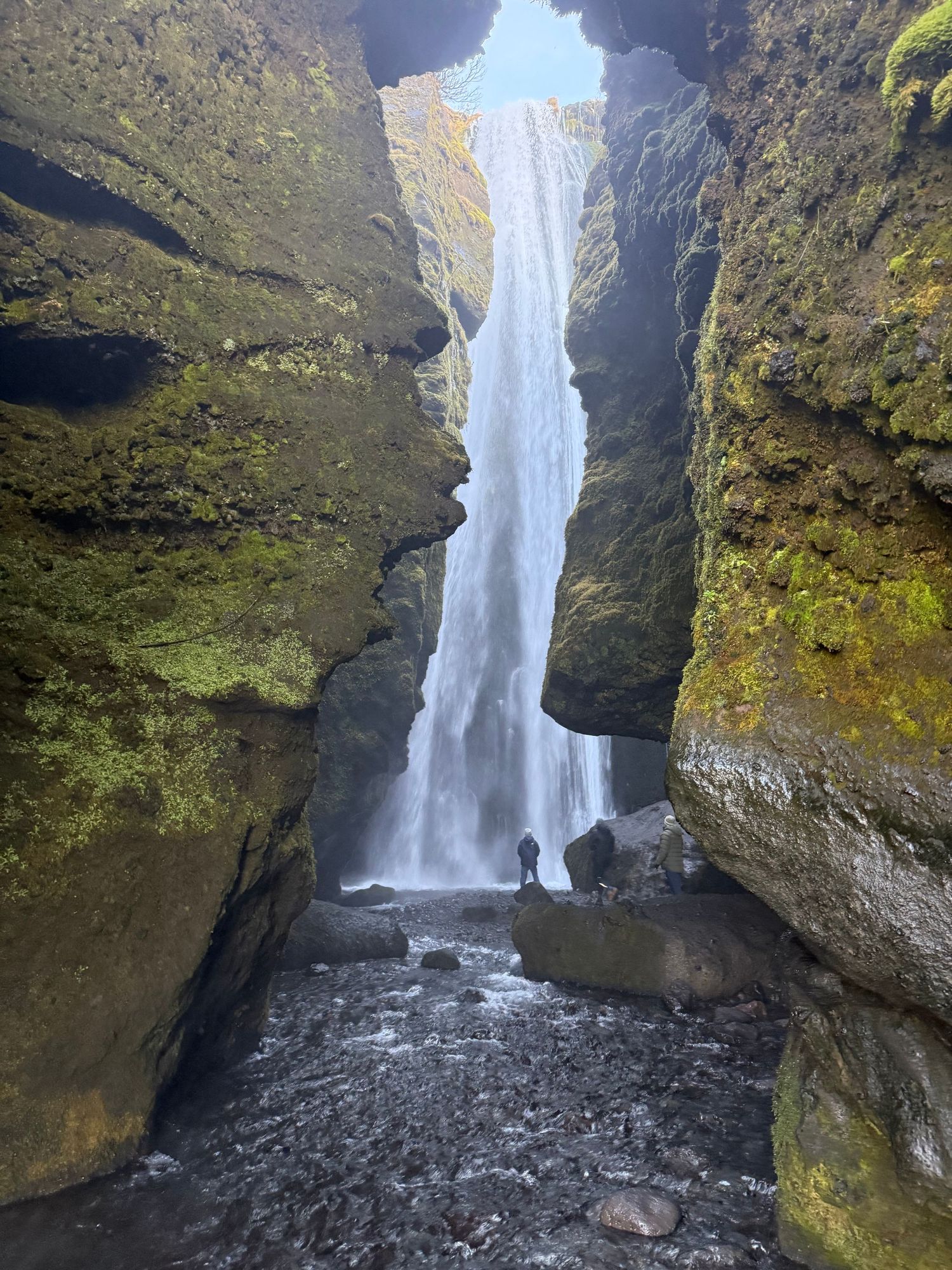 A dramatic waterfall cascades down moss-covered cliffs through a narrow rocky gorge in multiple scenic views.