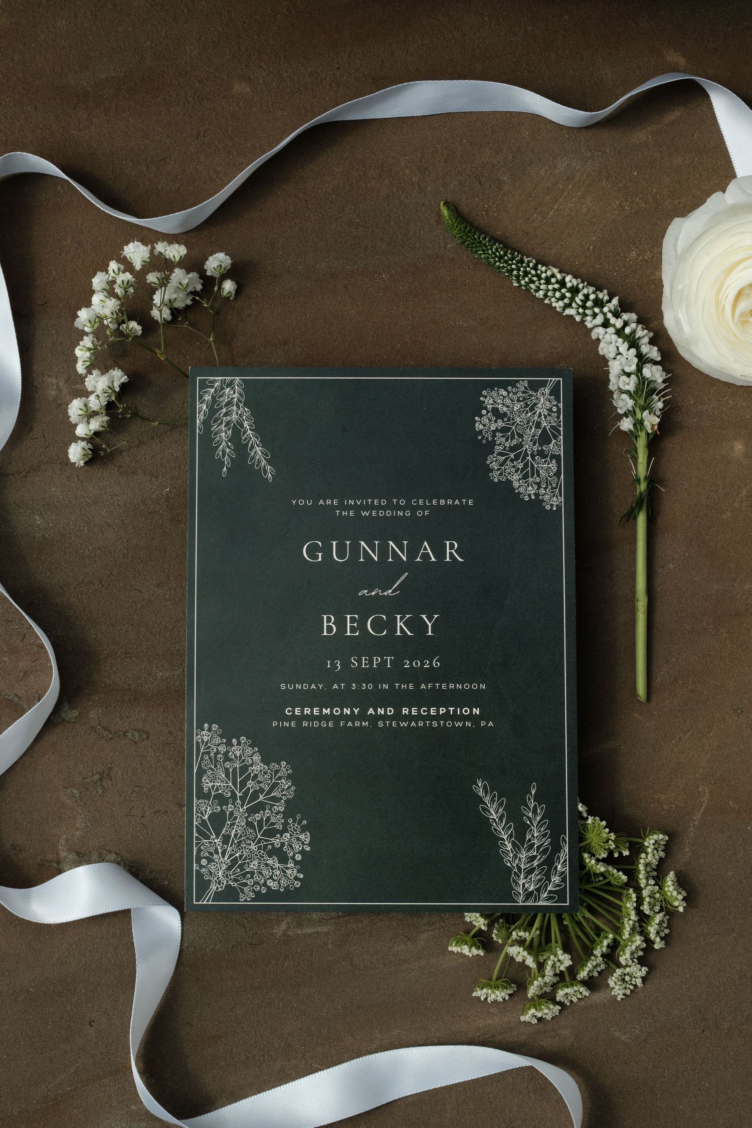 Dark green wedding invitation for Gunnar and Becky with botanical line art, surrounded by white ribbon, baby's breath and a cream rose.
