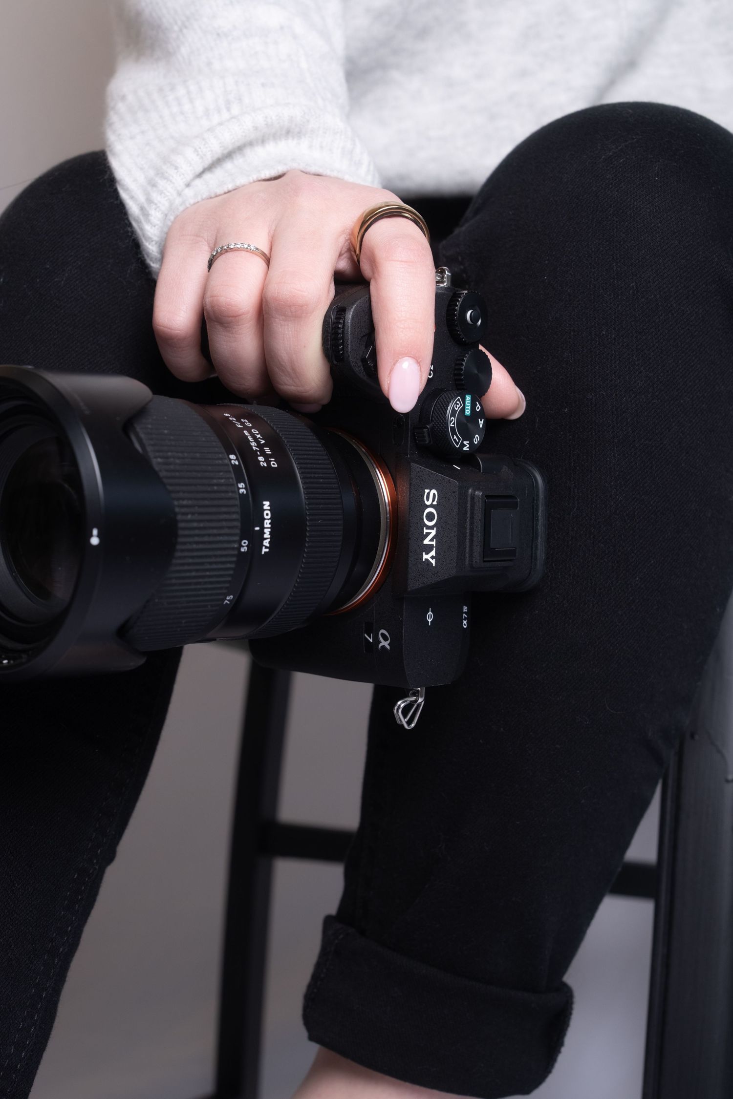 Close-up sequence showing hands adjusting settings and controls on a black DSLR camera lens.