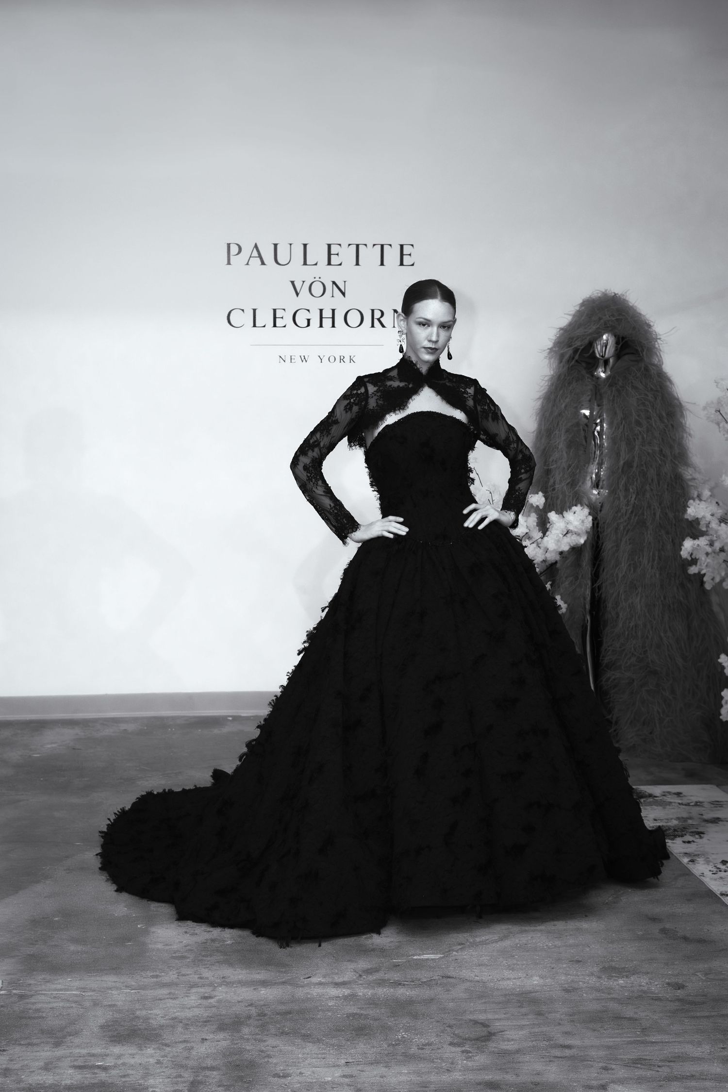 Model in black lace ball gown at Paulette Von Cleghorn New York fashion show runway presentation.