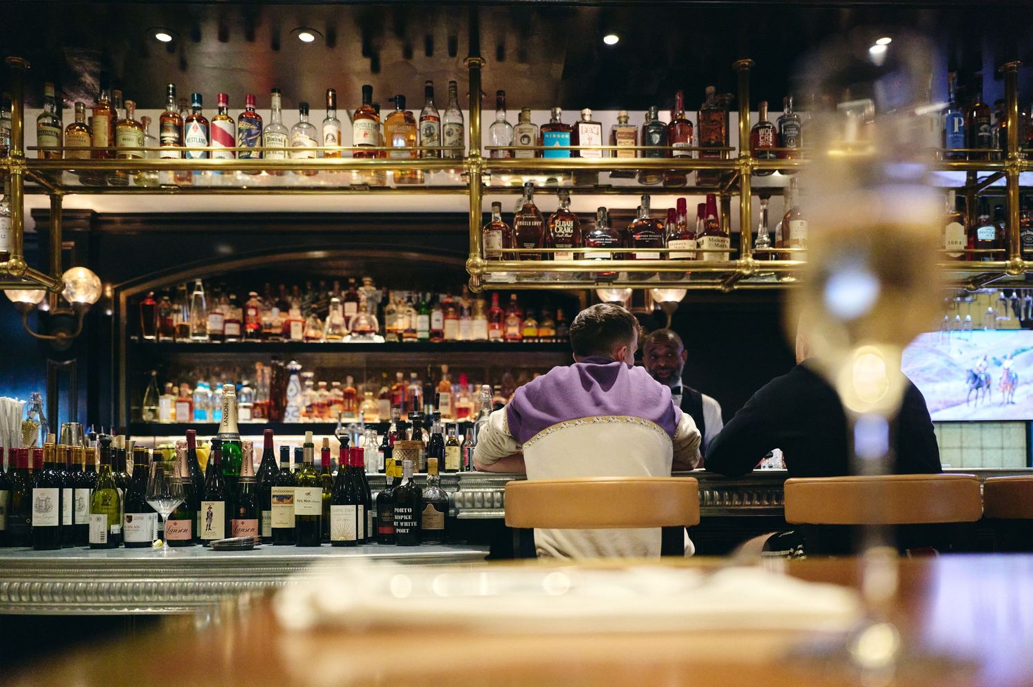 Bar counter with blurred bottles and glassware in low light setting.