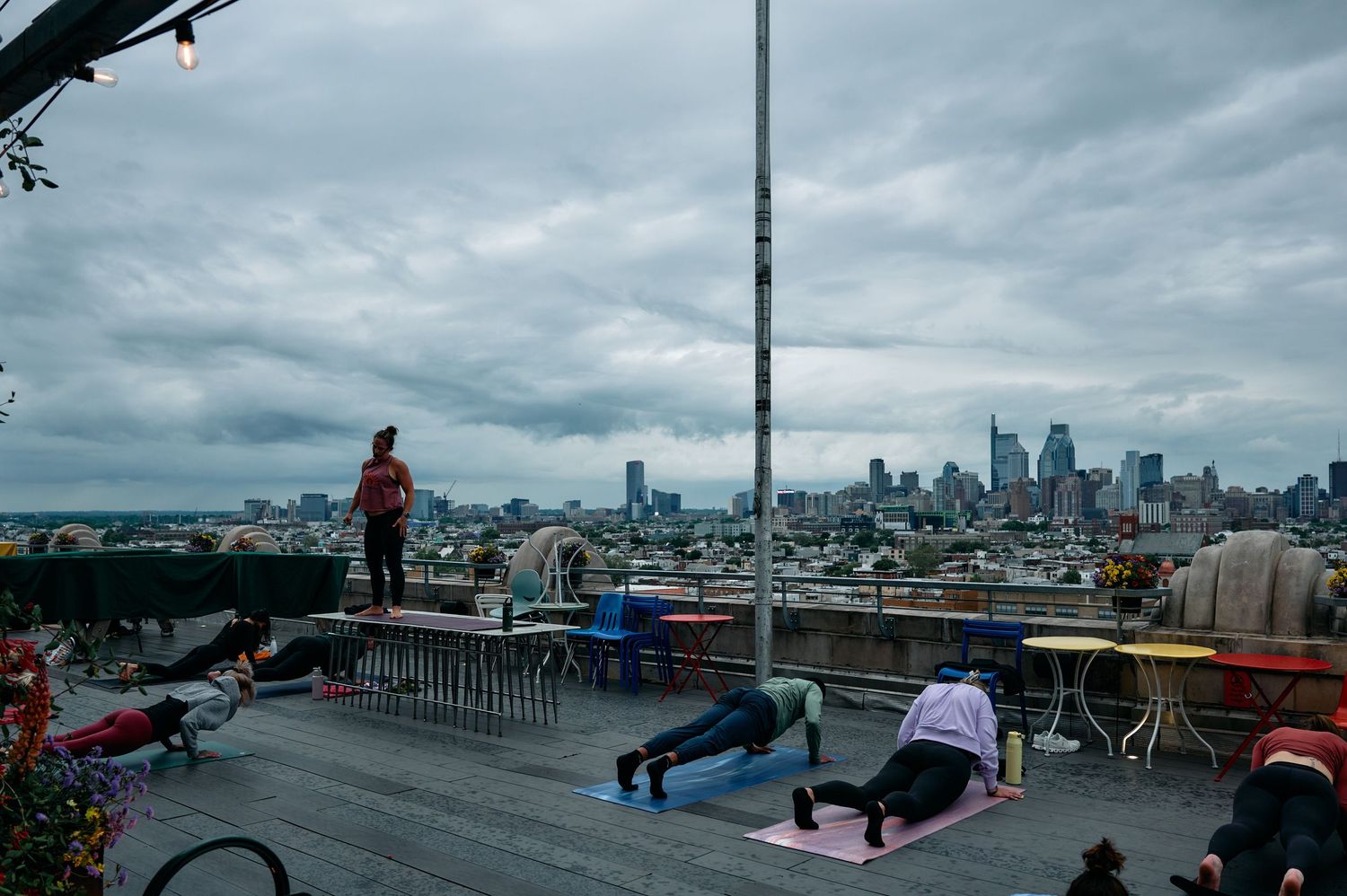 Panoramic cityscape view from rooftop showing urban skyline under cloudy skies.
