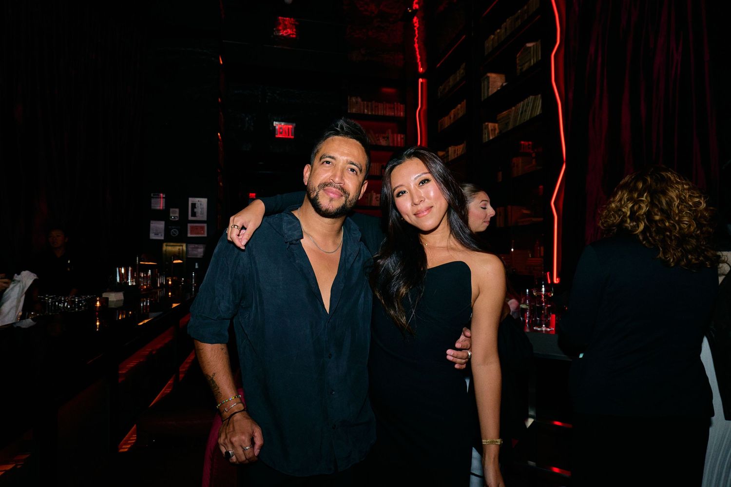 Group of friends socializing at a dimly lit nightclub or bar.