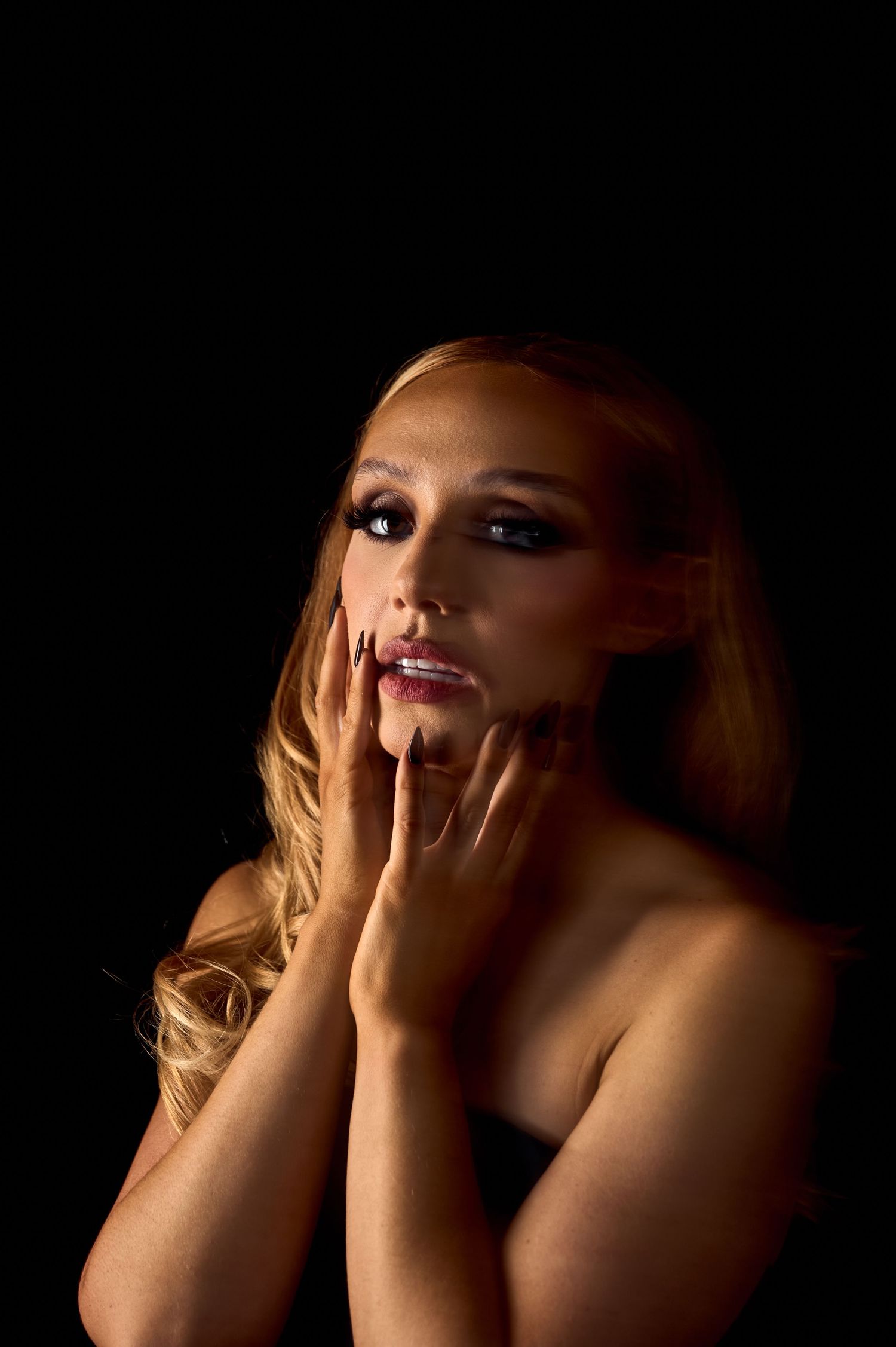 Dramatic portrait series showing hands framing face against dark background with warm lighting.
