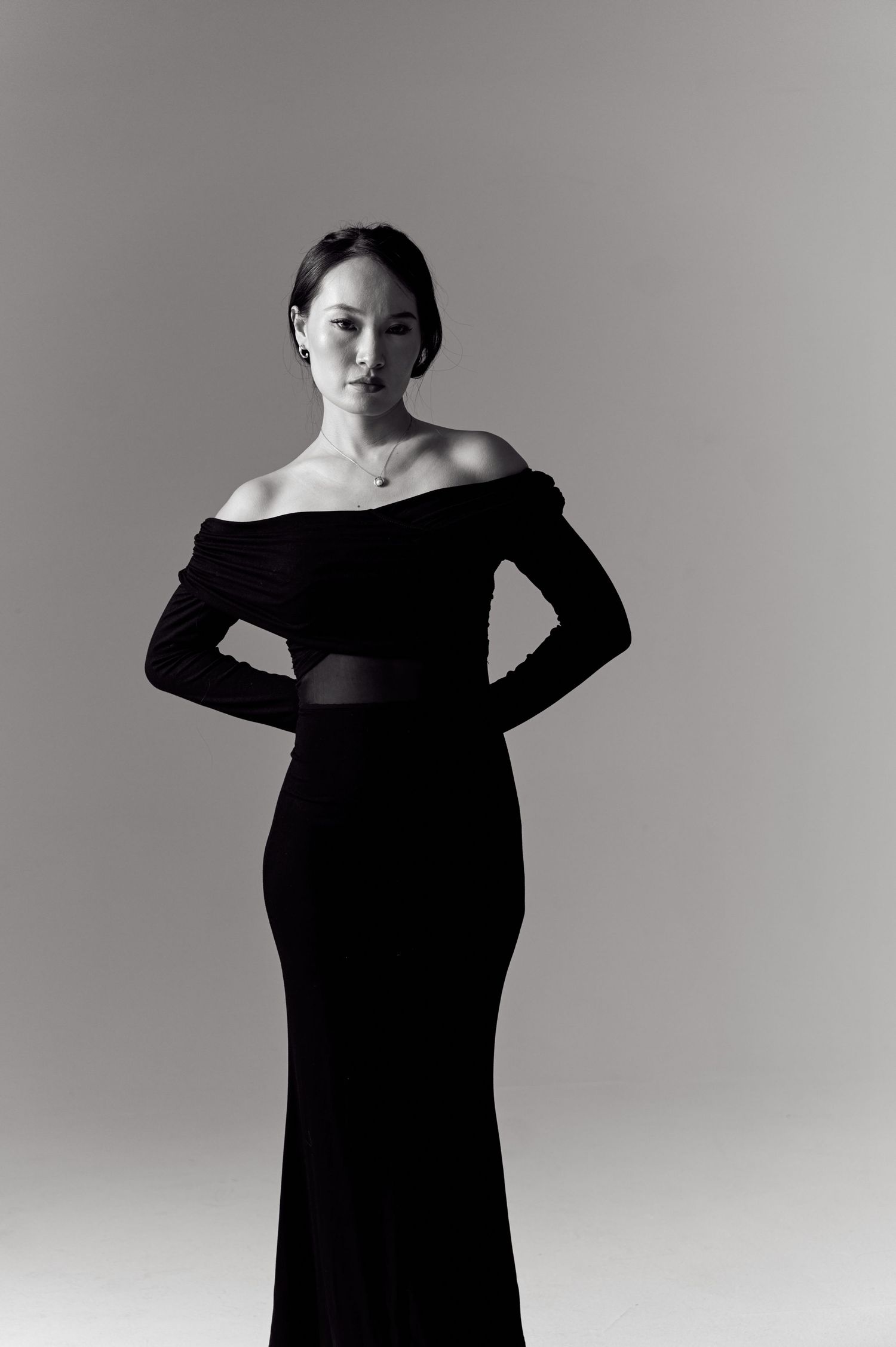 Artistic black and white portrait series showing poses in an off-shoulder dress.
