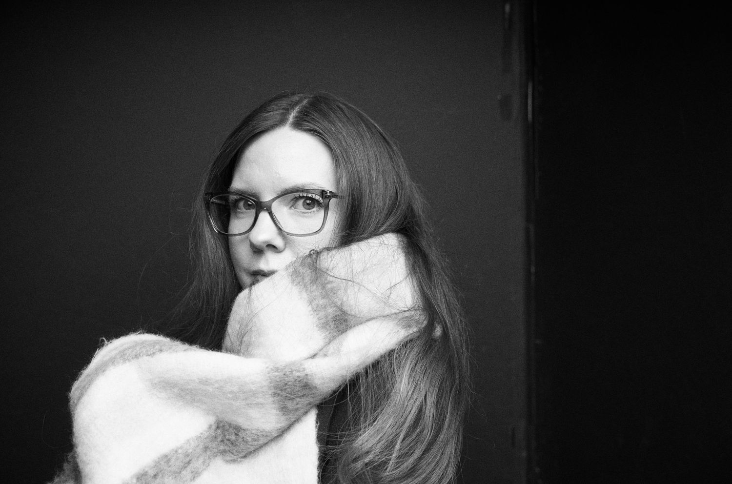 Dark artistic portraits showing various facial expressions in moody black and white lighting.