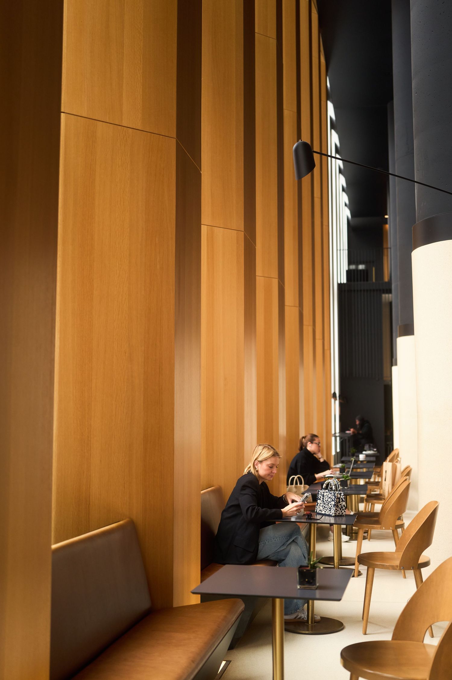 Modern restaurant interior with wooden columns and ambient lighting.
