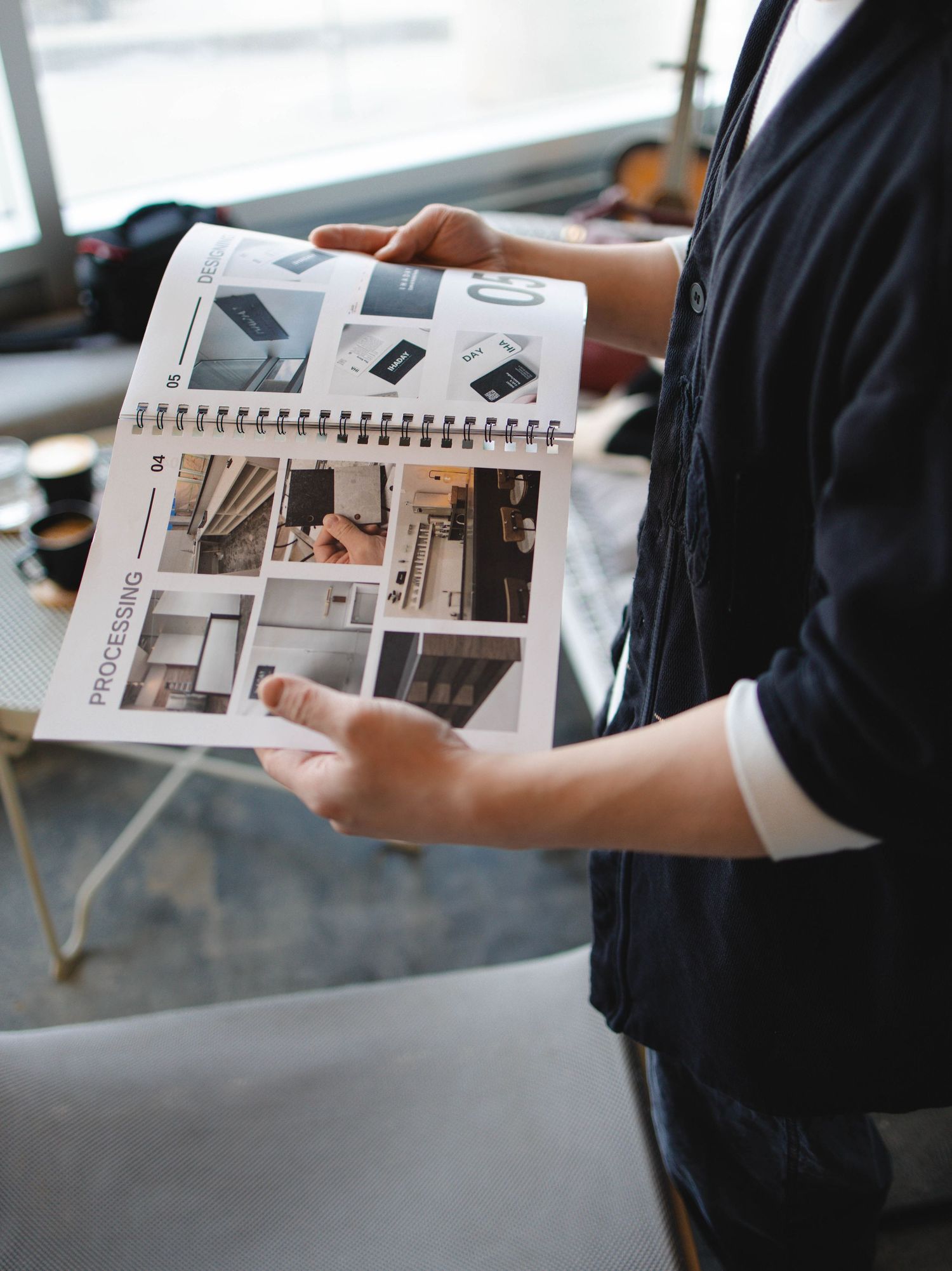 A man holding an interior design book and looking through the pages.