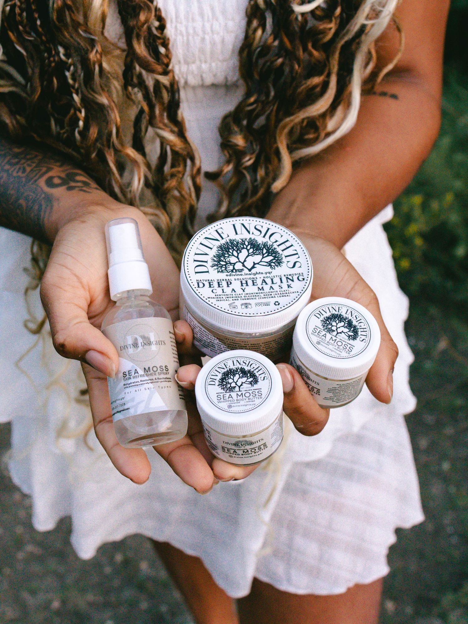 Woman holding branded skincare products in both hands.