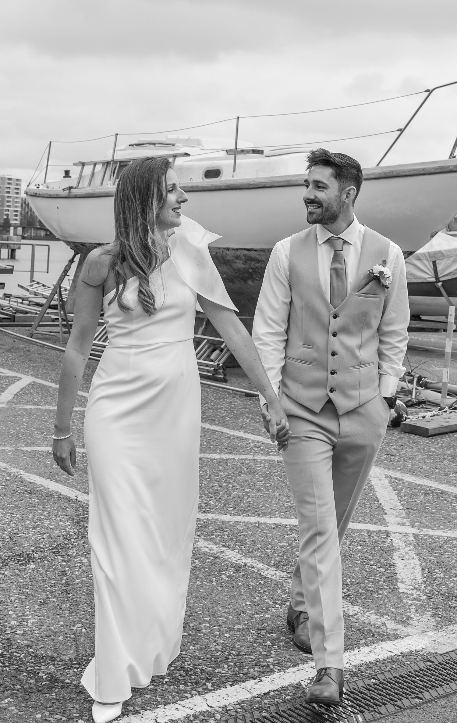 Black and white couple walking at Greenwich Yacht Club with boats in the background
