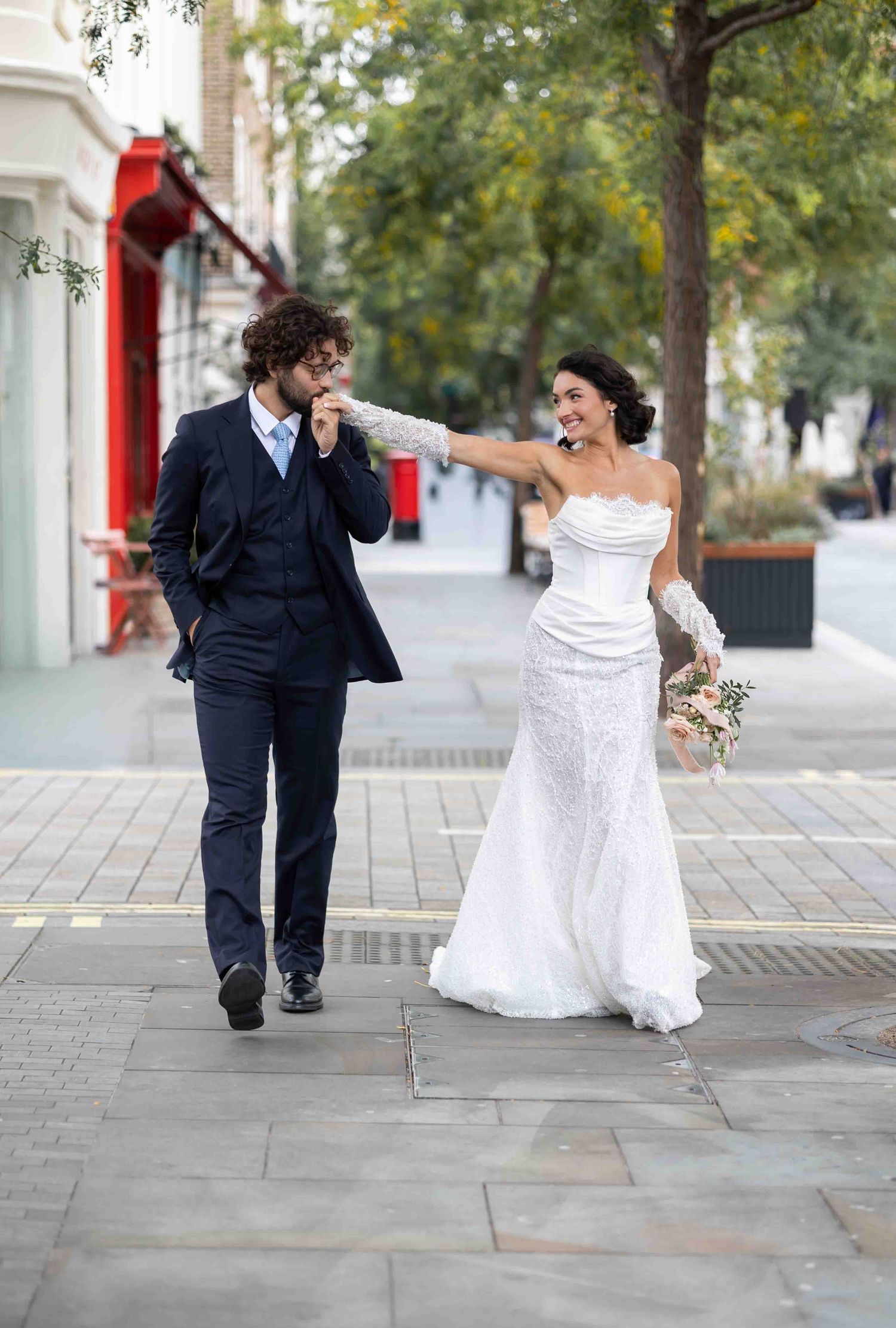 Playful bride and groom walking through Belgravia, London — elegant fine art wedding photography by Alba del Sol.