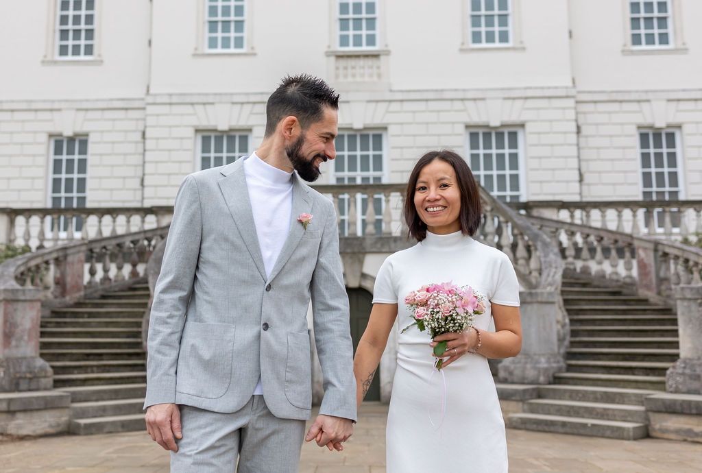Couple in elegant minimalist attire sharing a joyful moment outside the Queen’s House in Greenwich by Alba del Sol Wedding Photography