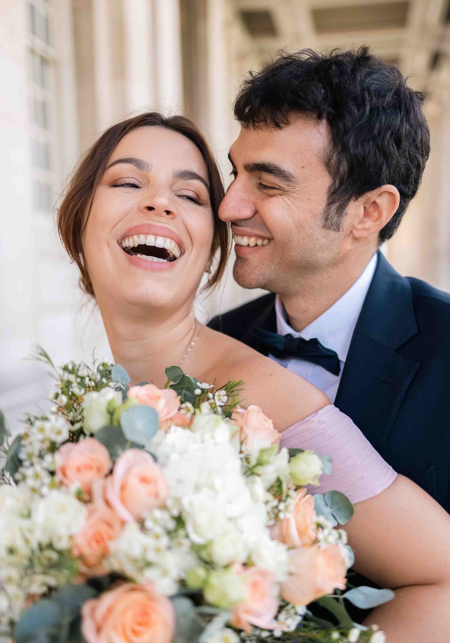Fine art wedding portrait of a joyful couple with peach and white bouquet at the Old Royal Naval College, London, photographed by AlbadelSol