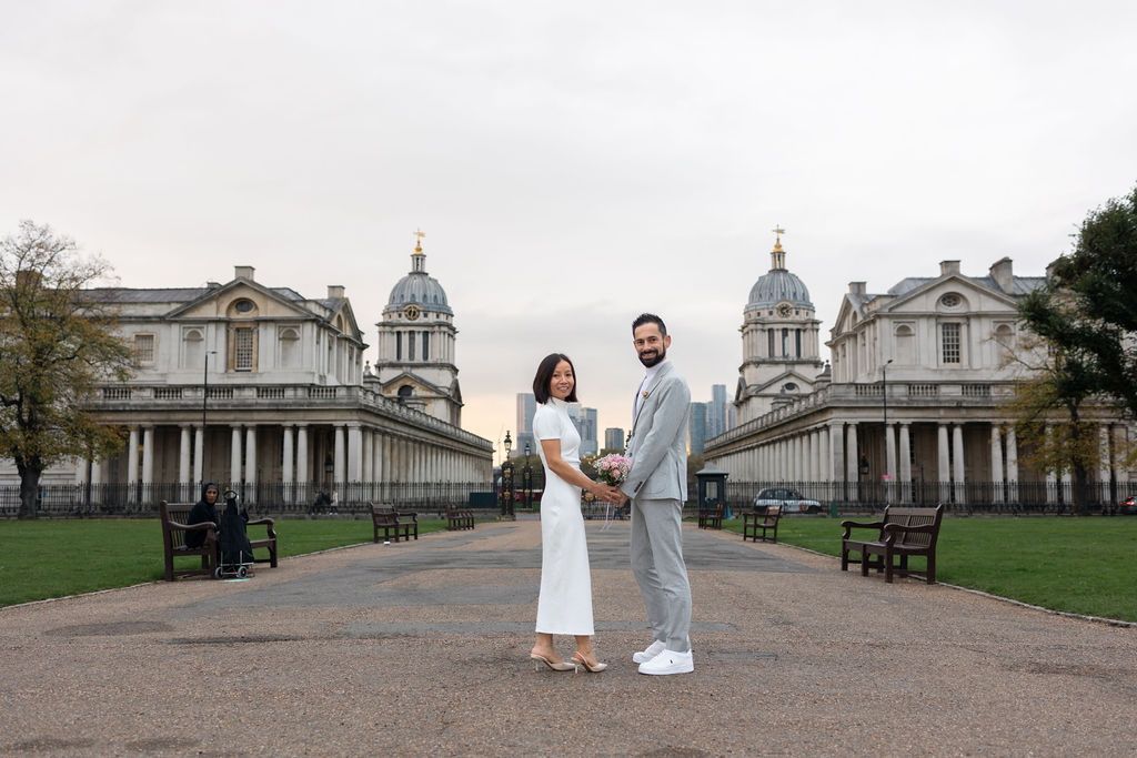 Elegant wedding couple holding hands in front of the Old Royal Naval College in Greenwich, London — modern and romantic wedding portrait