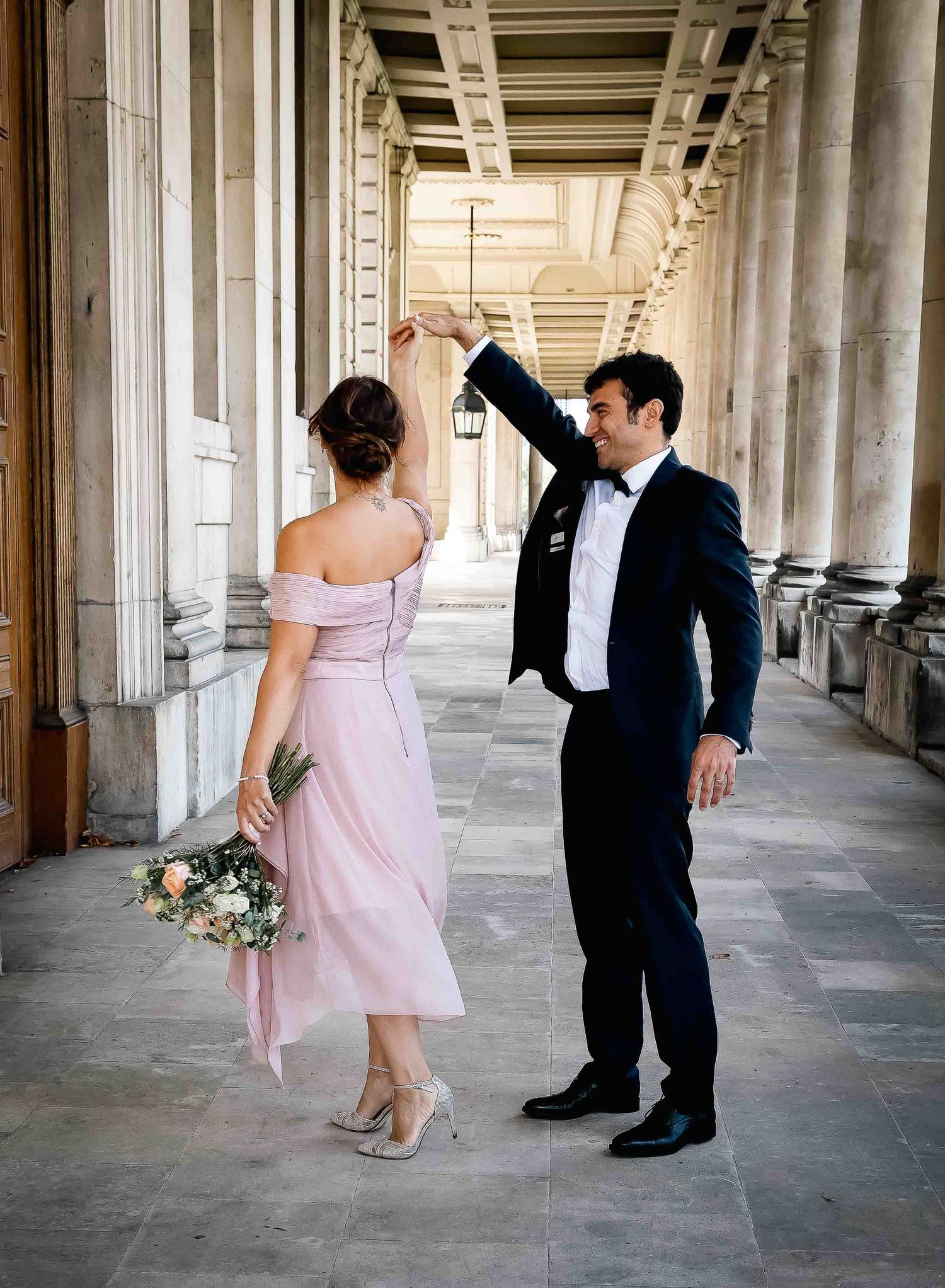 Bride and groom dancing under the colonnades of the Old Royal Naval College, London — elegant fine art wedding photography by Alba del Sol.