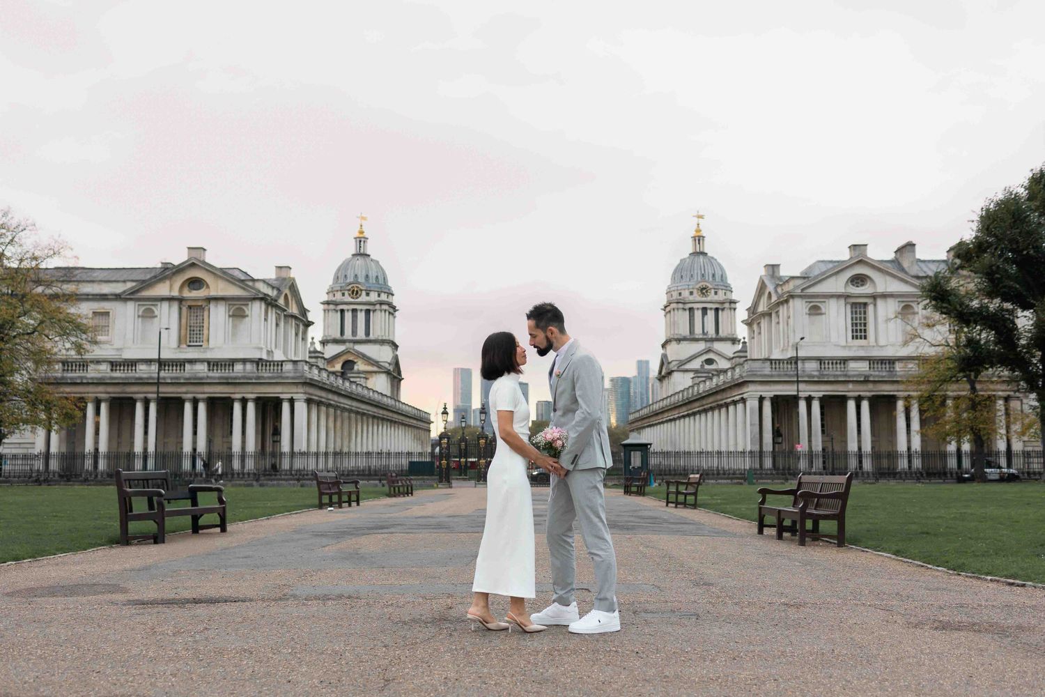 Elegant wedding couple about to kiss with the Old Royal Naval College and Canary Wharf skyline behind, captured by Alba del Sol
