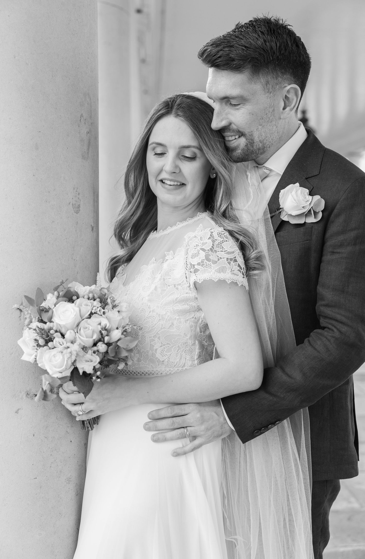 Romantic black and white portrait of a bride and groom embracing by the column at the Queen’s House in Greenwich, London — timeless fine a