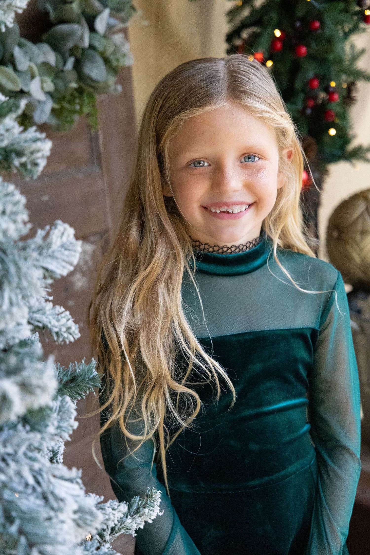 Young blonde girl dressed in green for Christmas portrait