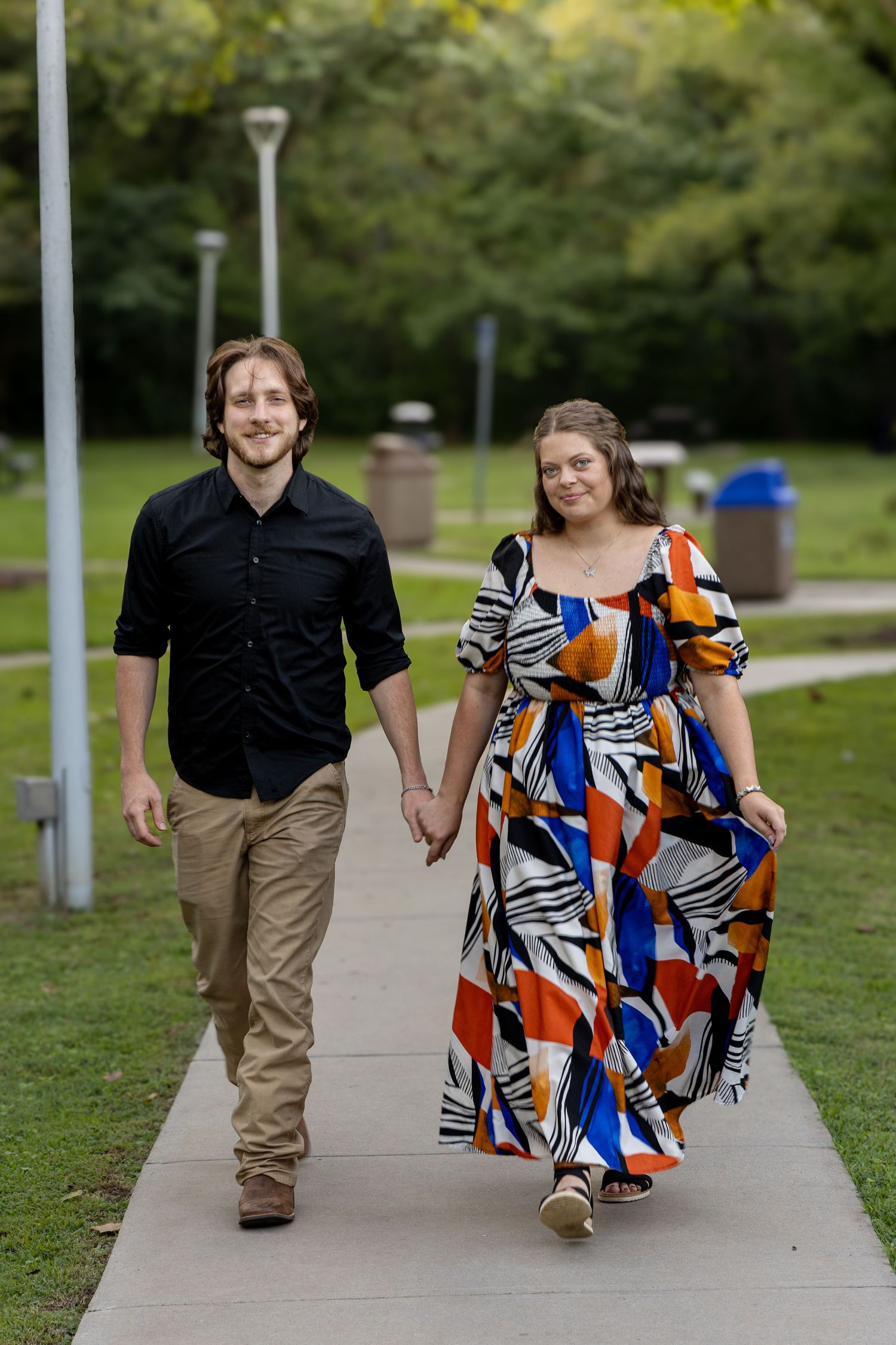 Newly engaged couple walking in a park