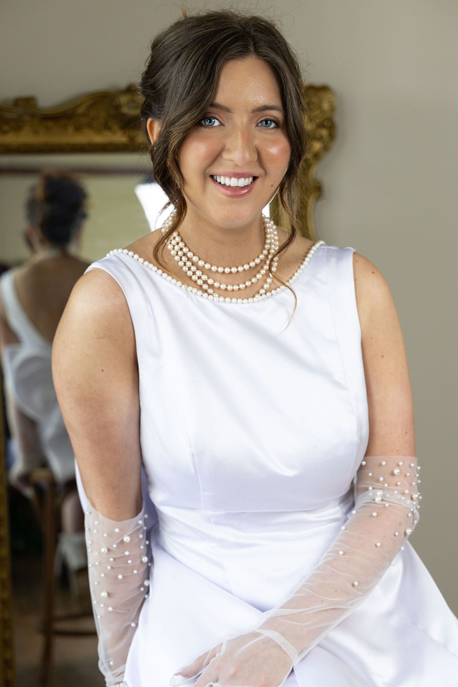 Bridal portraiture of beautiful bride in classic white dress, gloves and pearls
