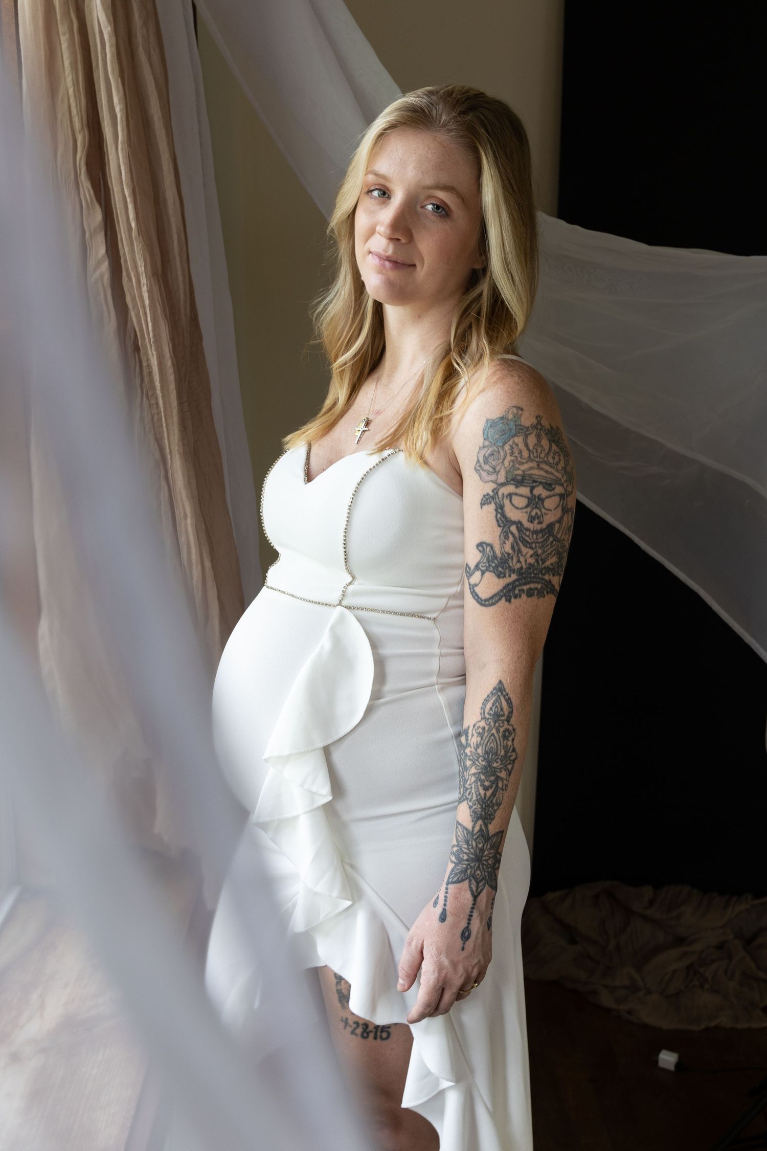 Portraiture of a pregnant mother in white dress and sheer backgrounds