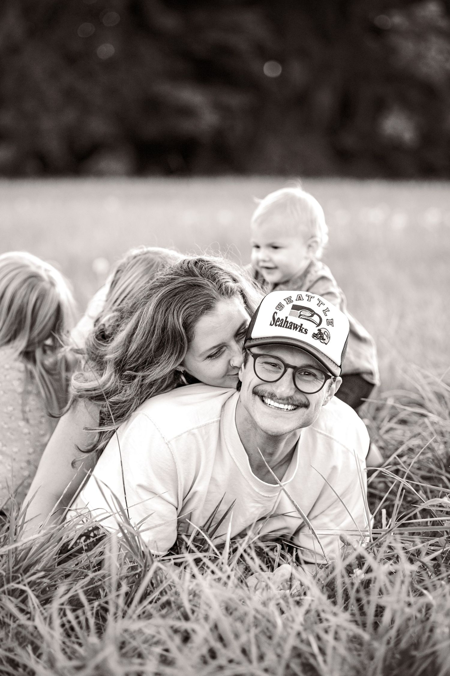 Golden hour family photo. Candid family photo. PNW family photo session in a field. Outdoor family photos.