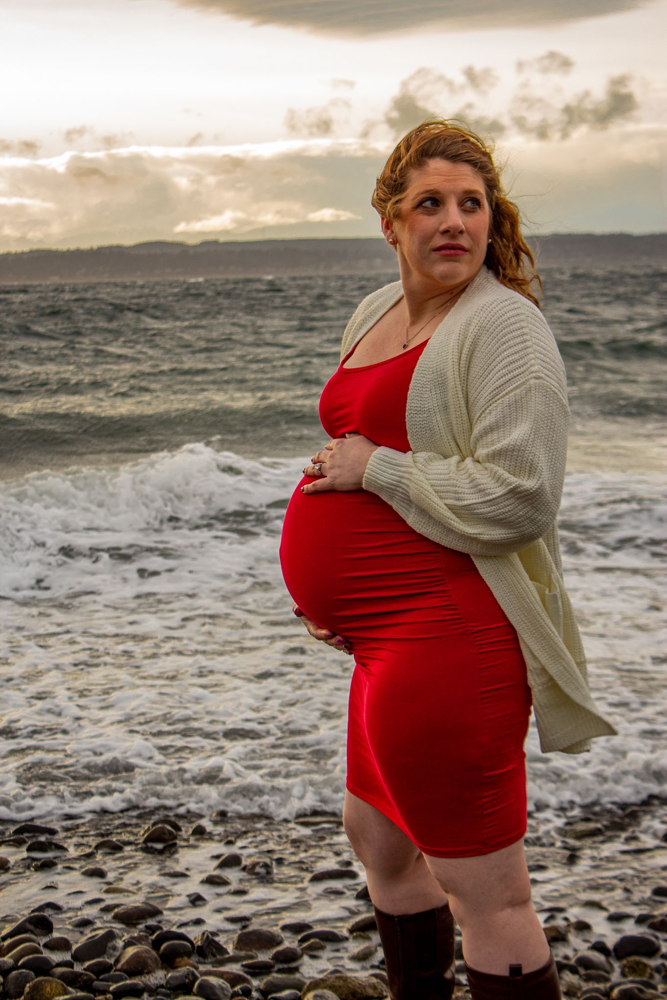 Maternity photos on the beach. Candid maternity photo. Moody. beach and the puget sound in the background. dark skies. Windy day