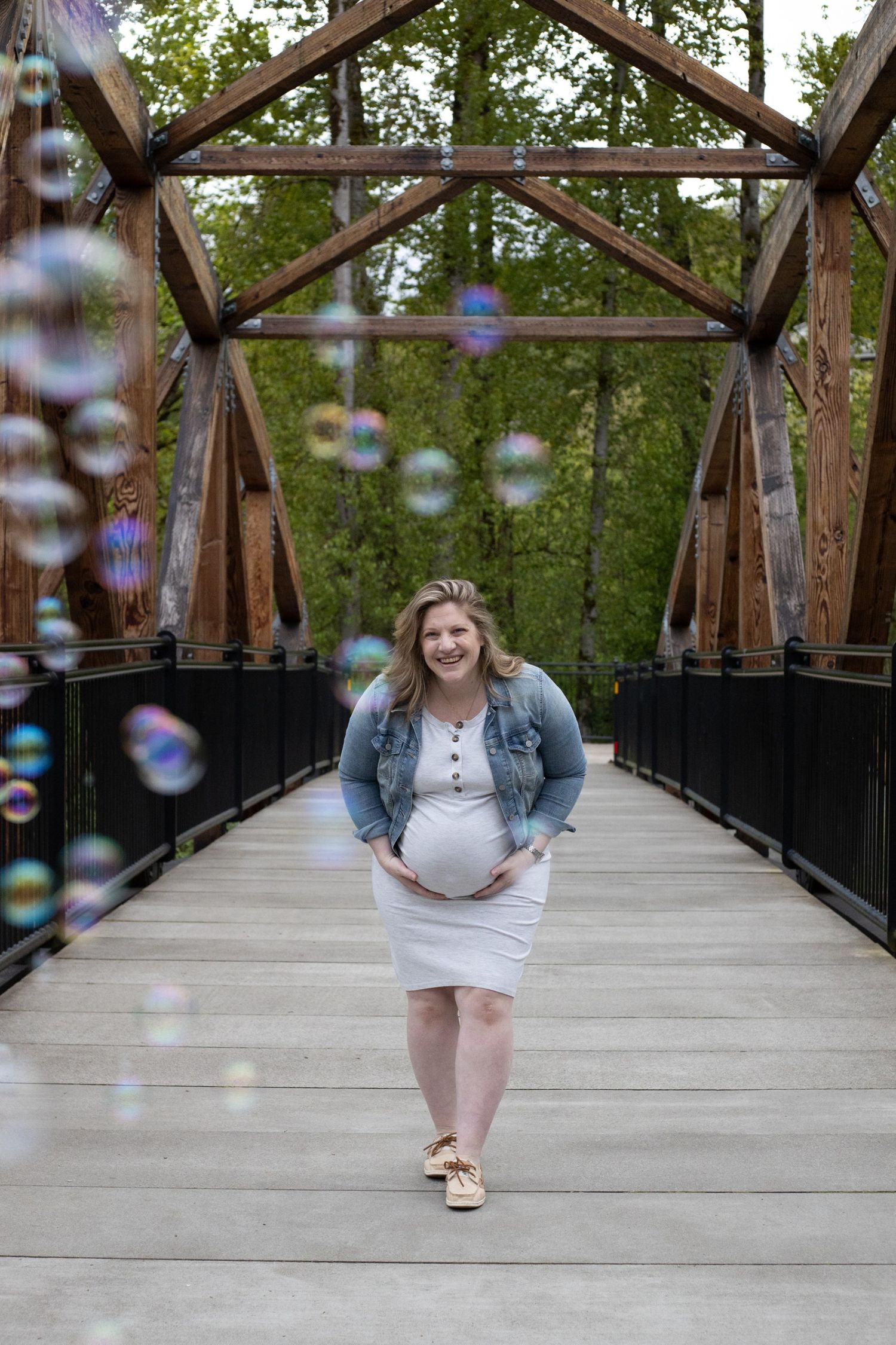 Maternity photos on a bridge with bubbles. Candid maternity photo. Moody.