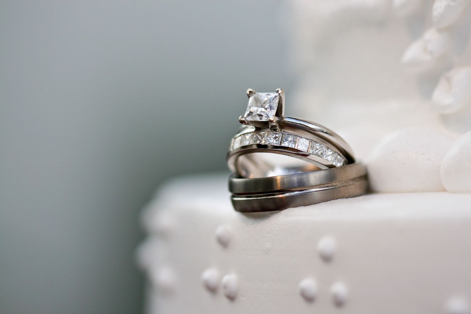 Close-up of diamond engagement ring and wedding band on the couples wedding cake.