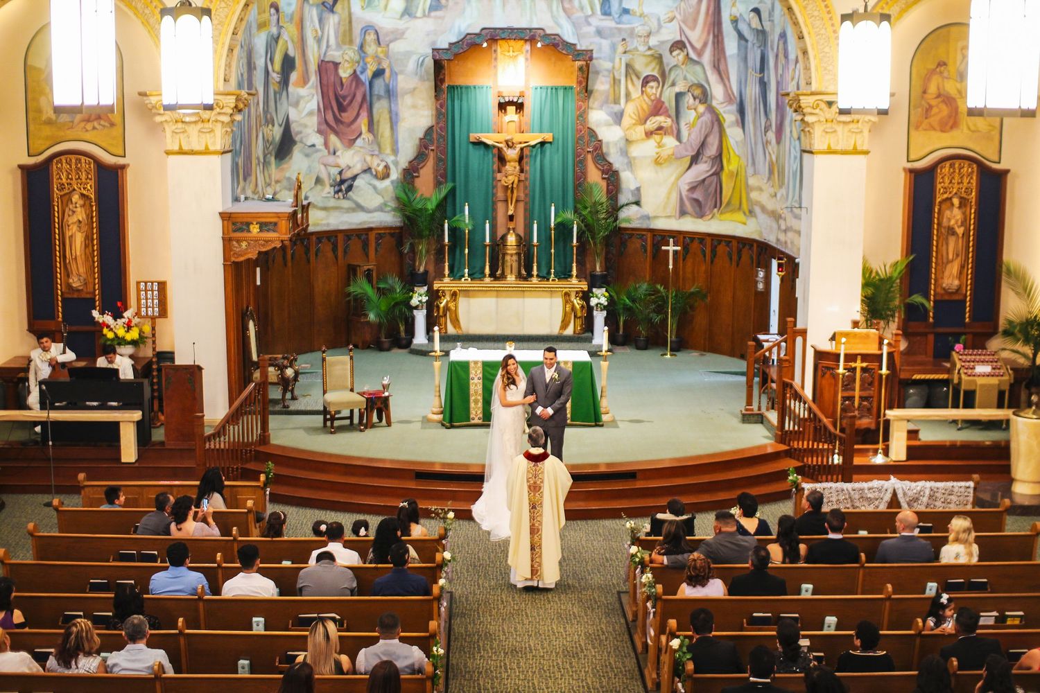 Interior of a church with ornate murals and traditional wooden pews.
