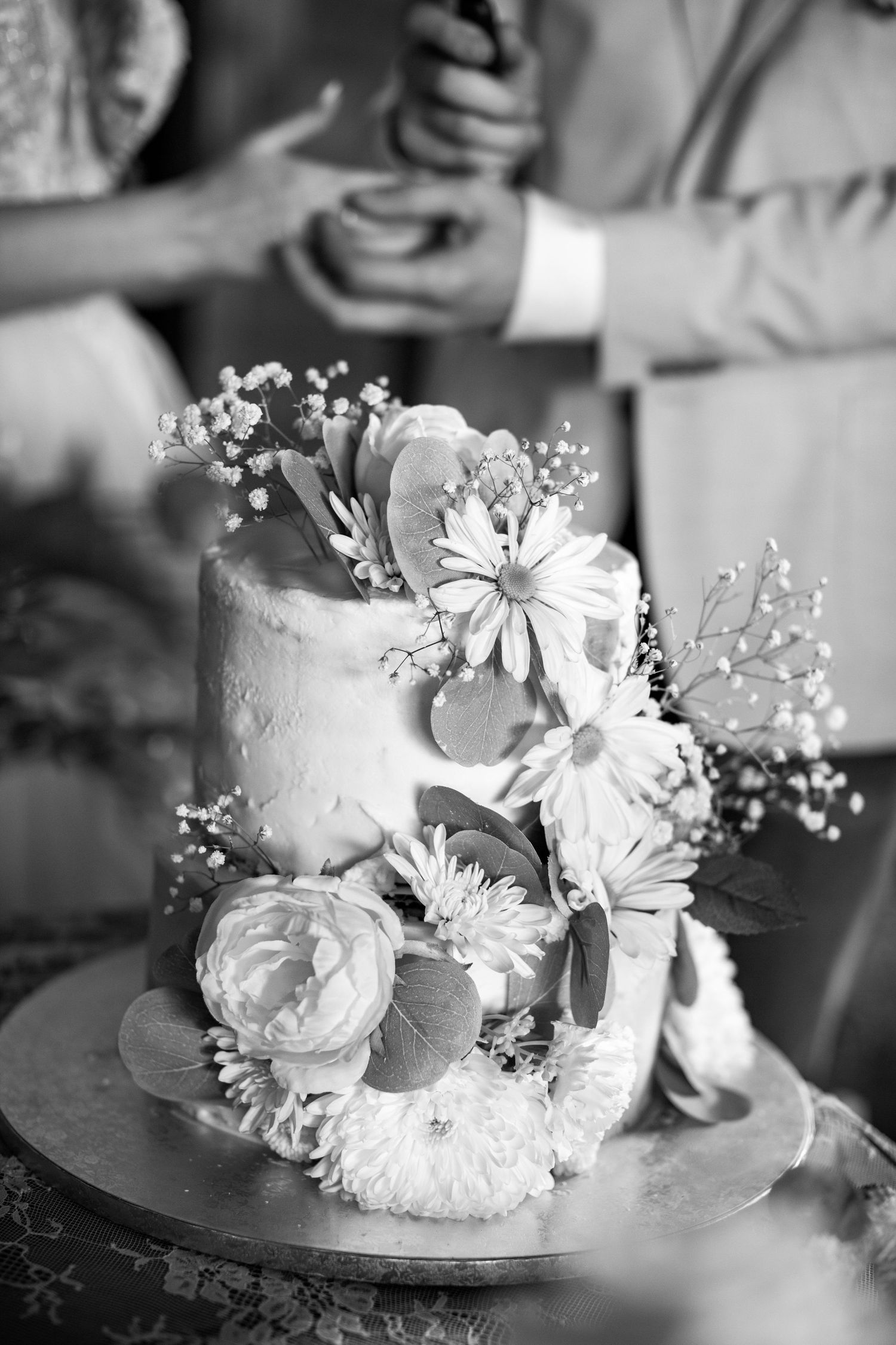 An elegant white wedding cake decorated with delicate flowers and baby's breath.