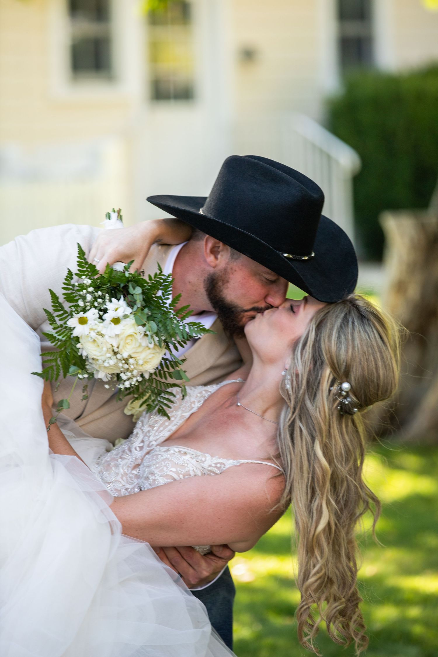 Newlyweds share tender kisses in a series of romantic outdoor wedding photos.