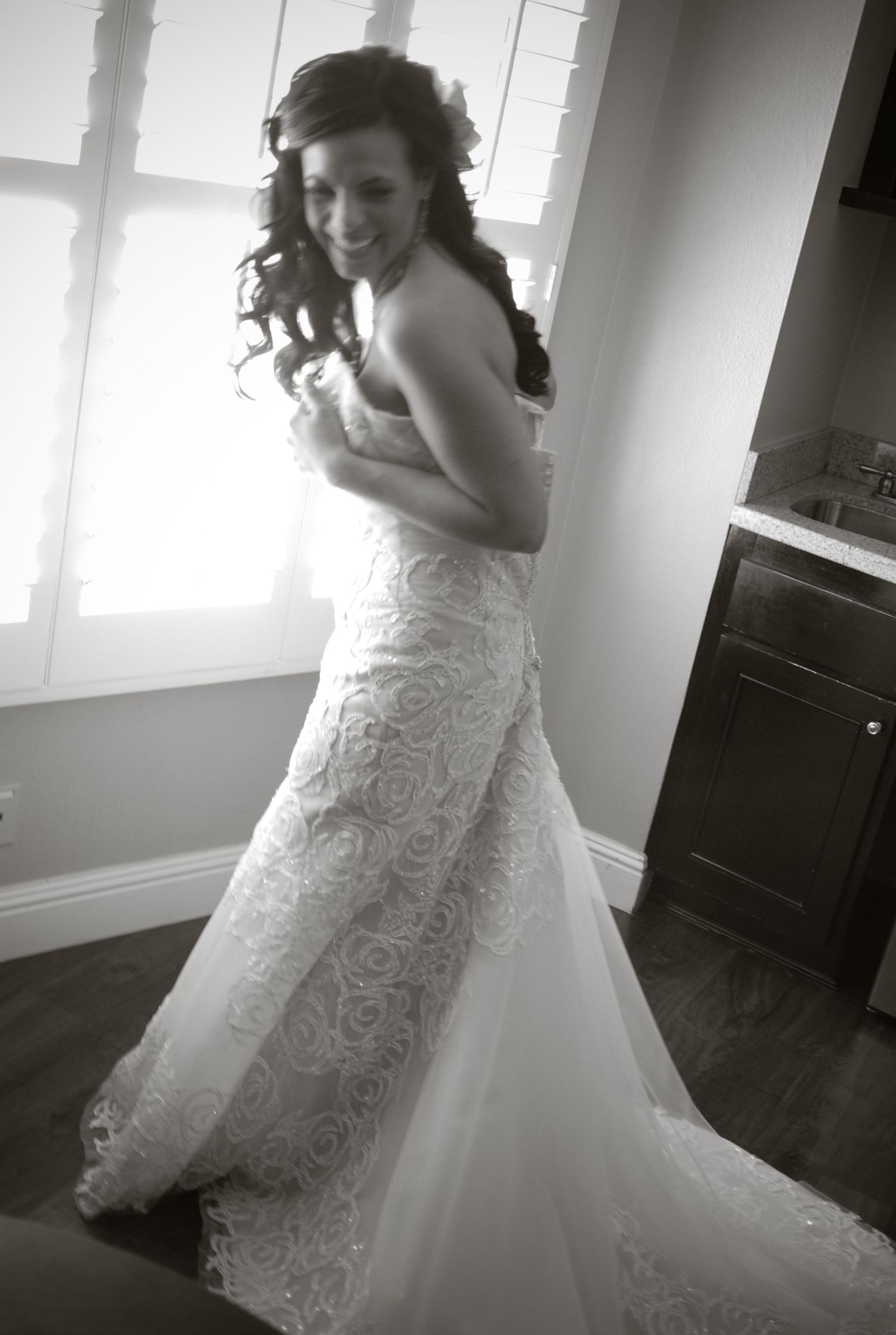 Artistic black and white series capturing the movement and details of an elegant bridal gown.