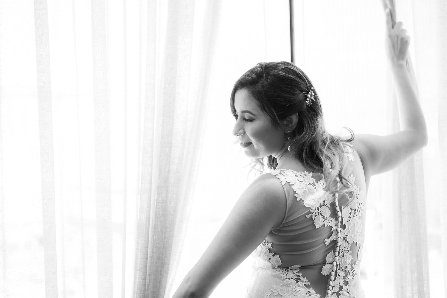 Artistic black and white portrait of bride in detailed lace gown.