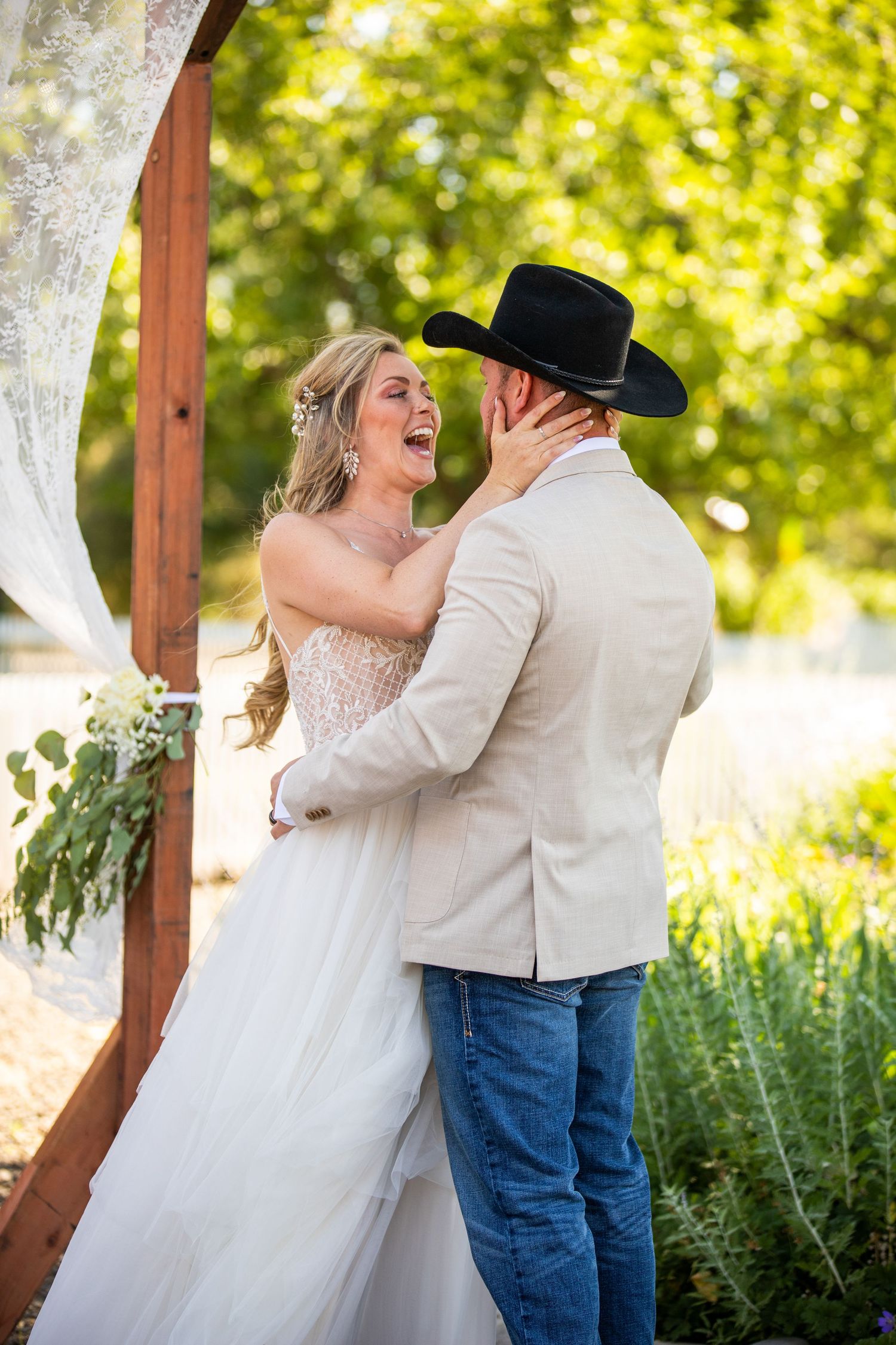 A couple shares a romantic moment in a sun-drenched garden setting.