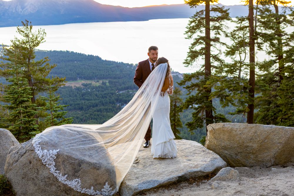 Wedding dress train flowing dramatically against mountain landscape at sunset in  Heavenly Mountain resort Lake Tahoe..