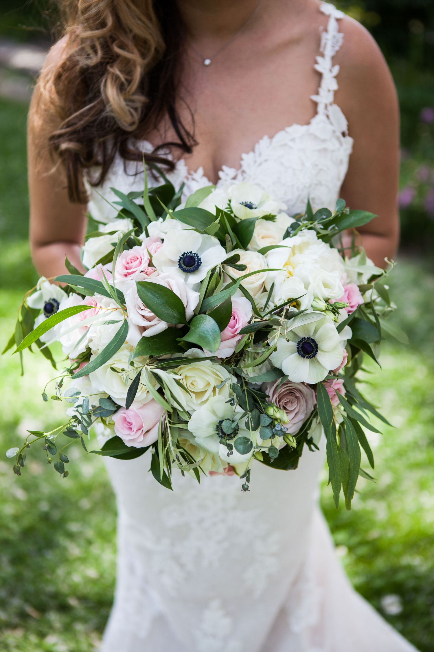 Stunning bridal bouquet features white anemones, pink roses and fresh greenery.