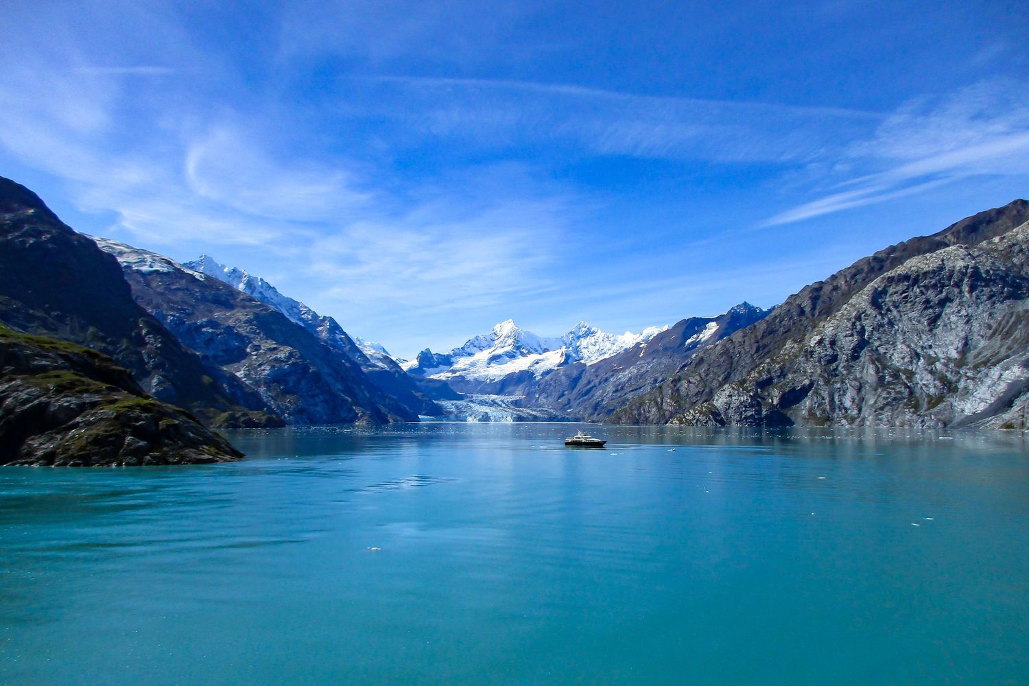 Landscape photography of stunning panorama of Alaska's glacier bay with crystal blue waters and mountain peaks.