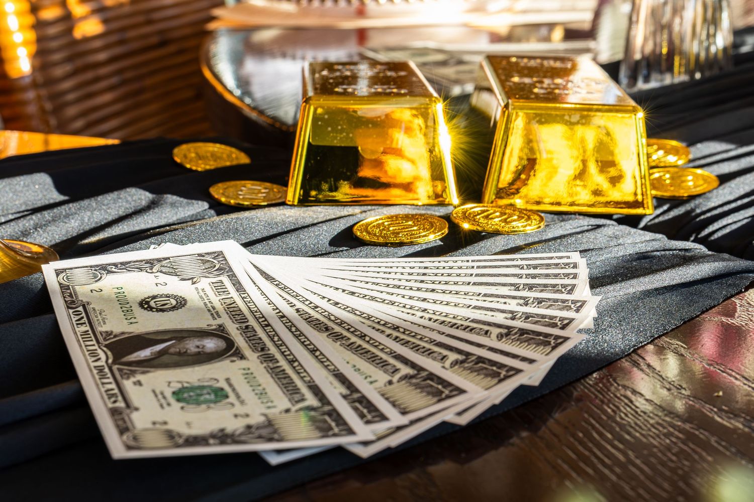 Spread of US dollar bills on dark surface with glowing golden tequila shots in glass containers.
