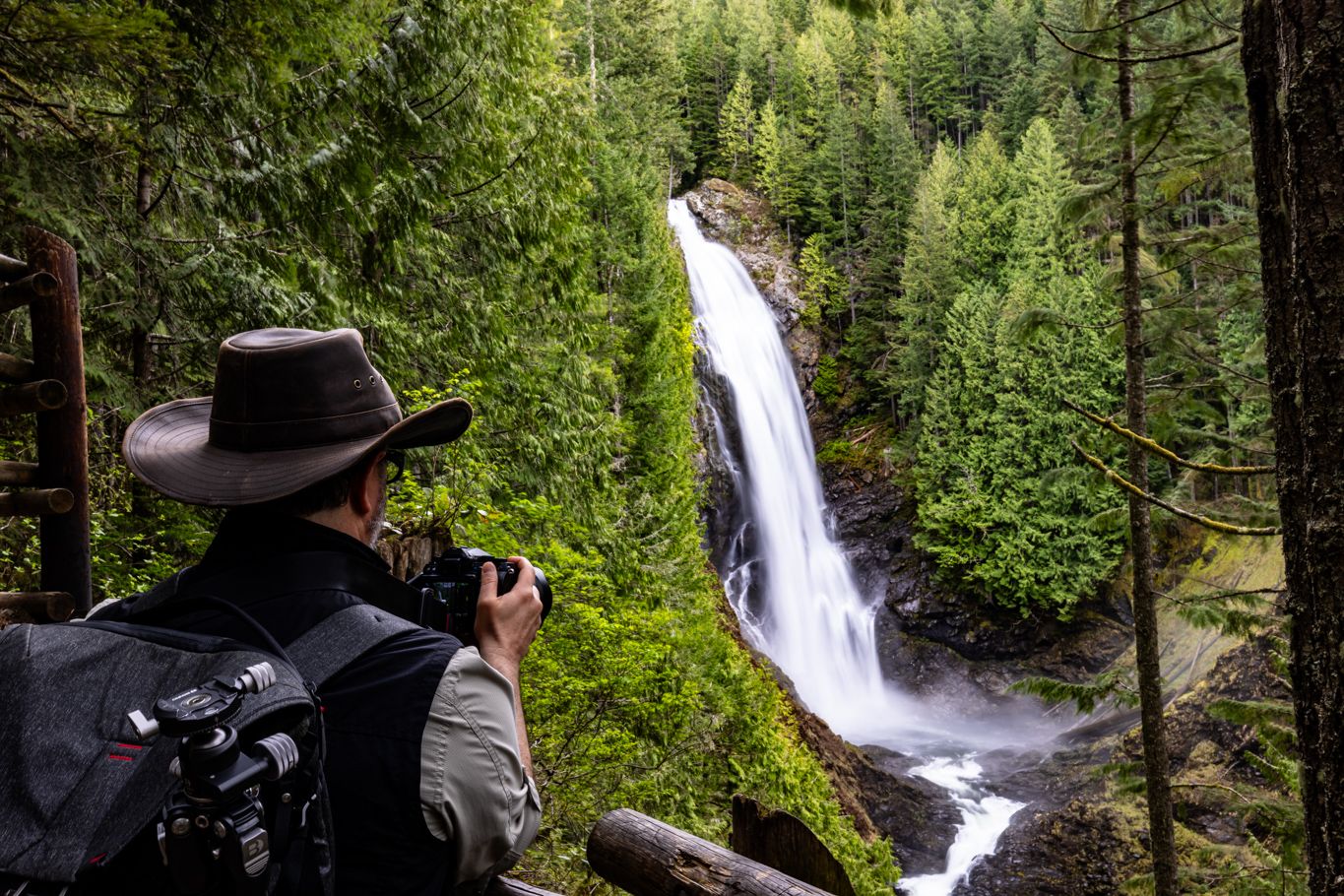 Pacific Northwest photographer captures a majestic waterfall cascading through lush green forest.