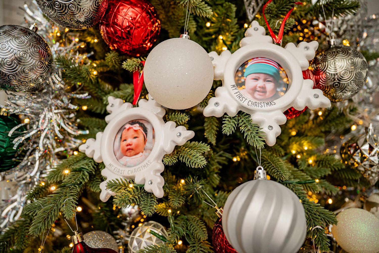 Christmas tree decorated with snowflake photo ornaments featuring baby portraits, silver balls, and twinkling lights. Stockton photographer