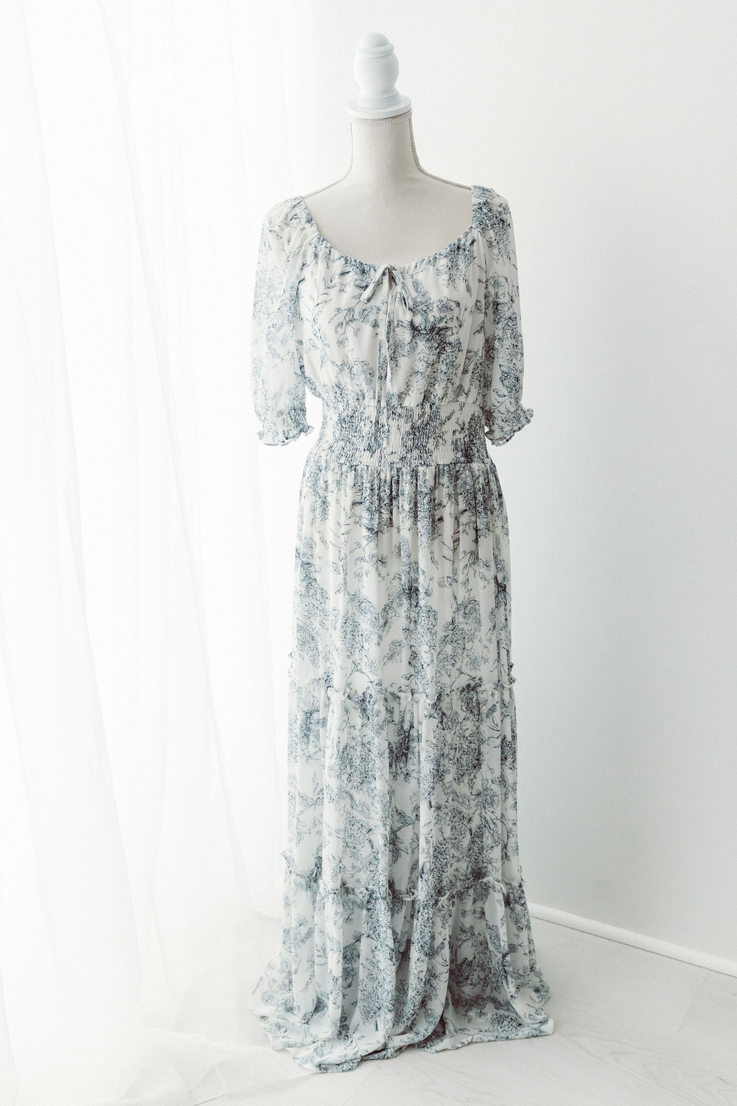 Blue floral print chiffon off-shoulder smocked waist maxi dress on mannequin.