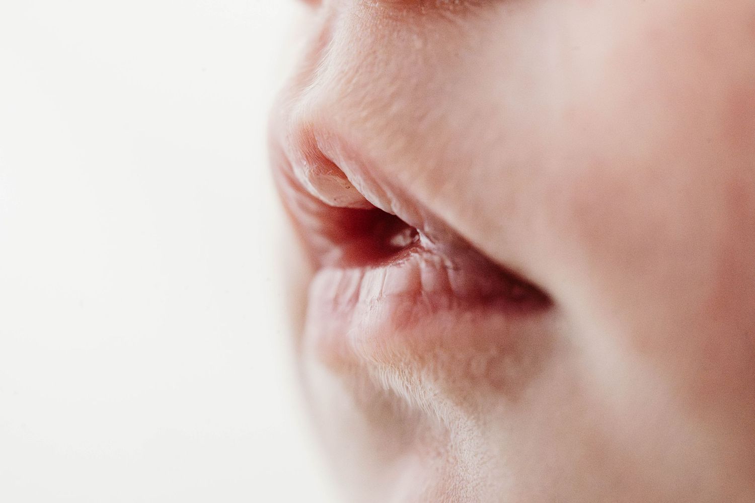 An extreme close-up macro photo of a newborn baby's nose and lips showing delicate skin details.