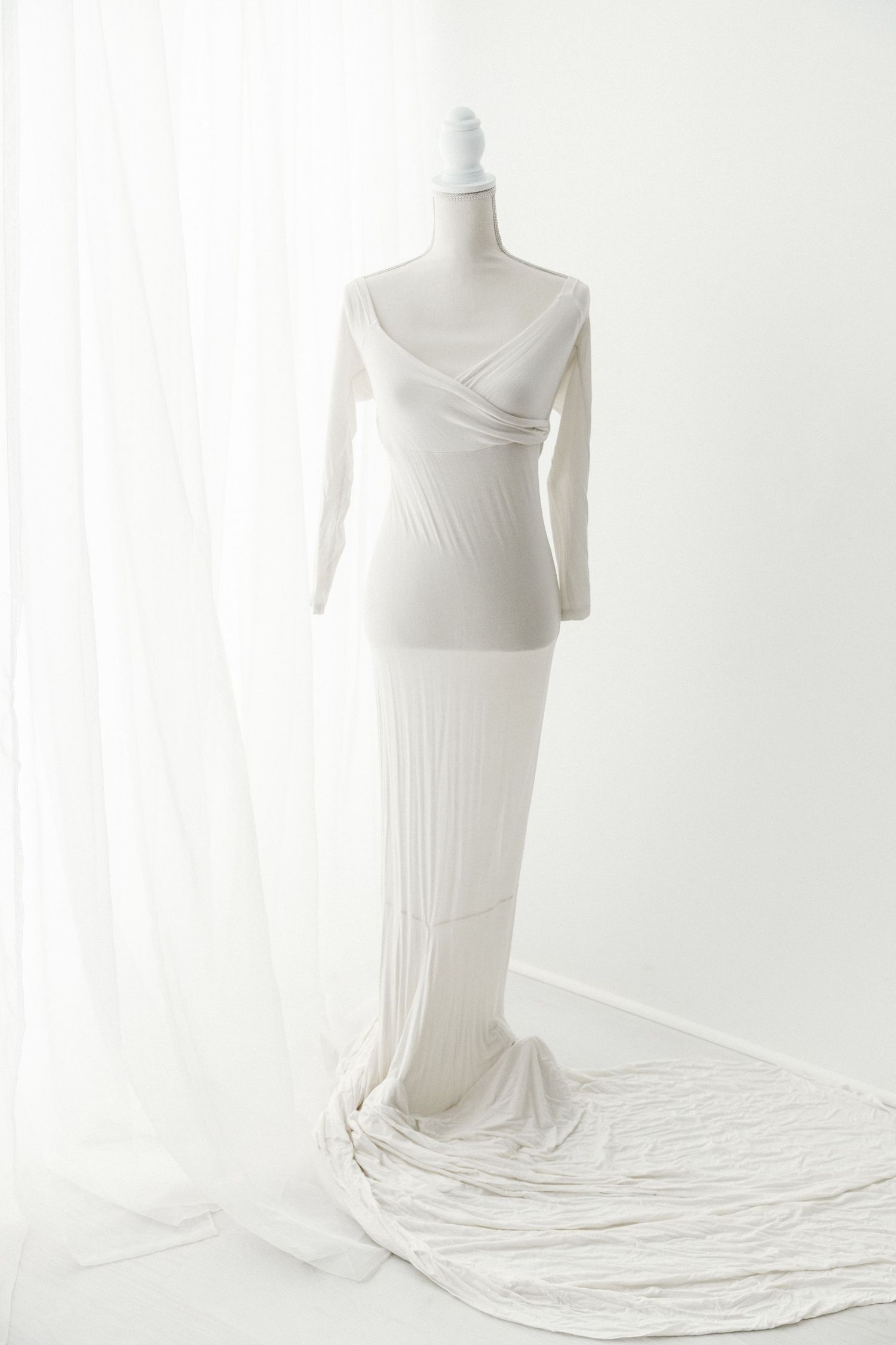 White ribbed long sleeve wrap maternity gown with train on mannequin.