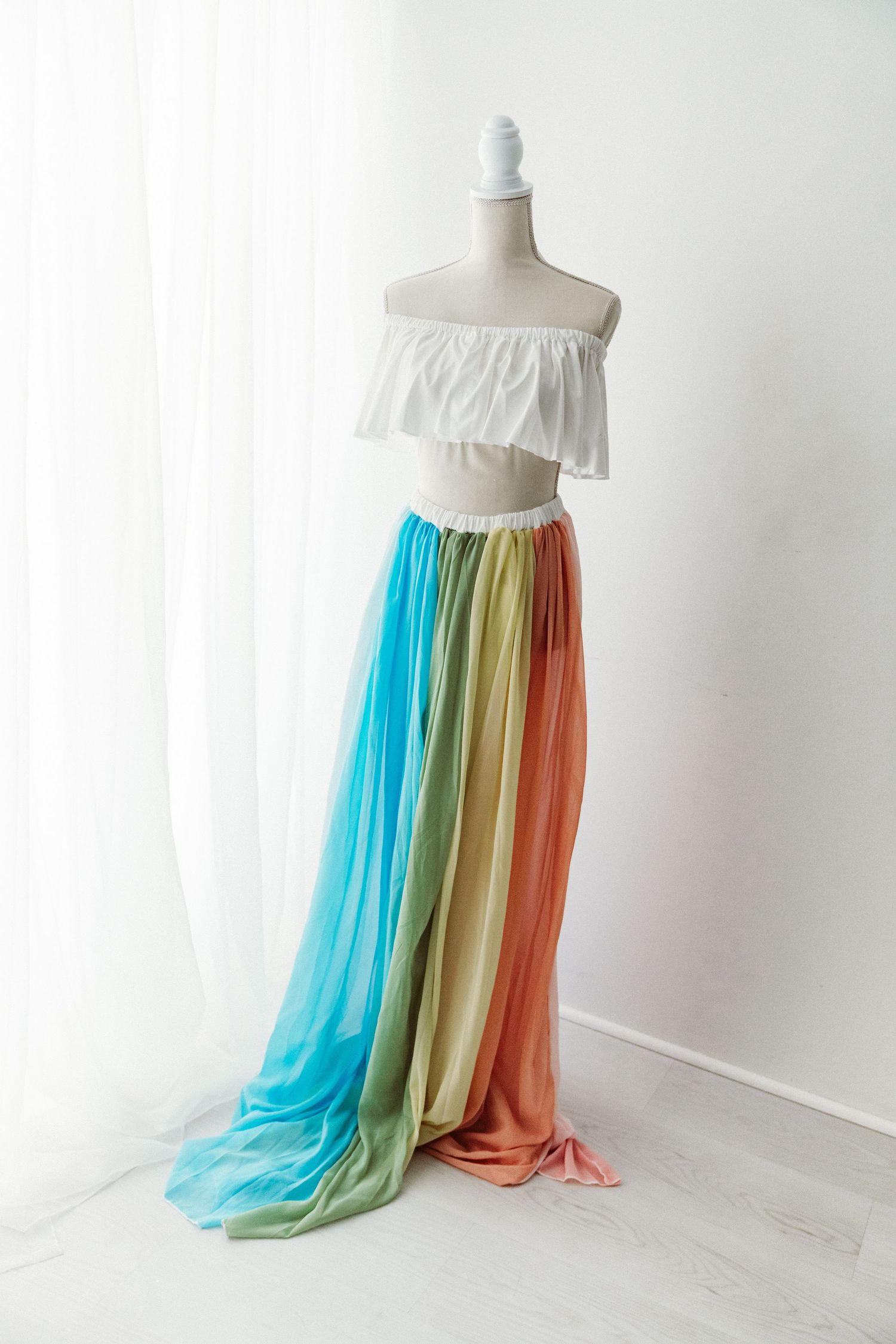 White ruffled crop top with rainbow colorblock chiffon skirt on mannequin.