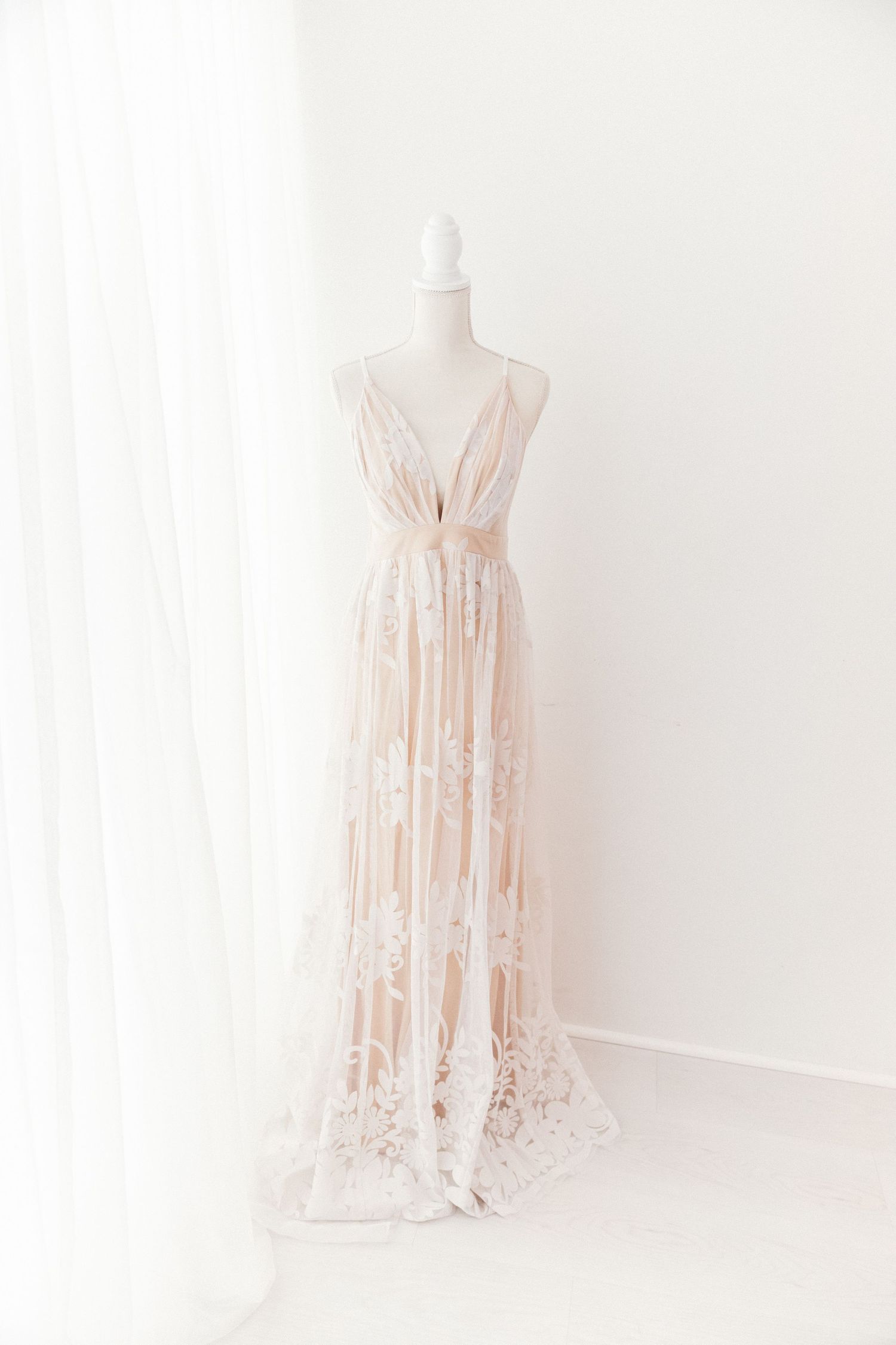 Blush lace floral spaghetti strap deep V-neck maxi dress on white mannequin.