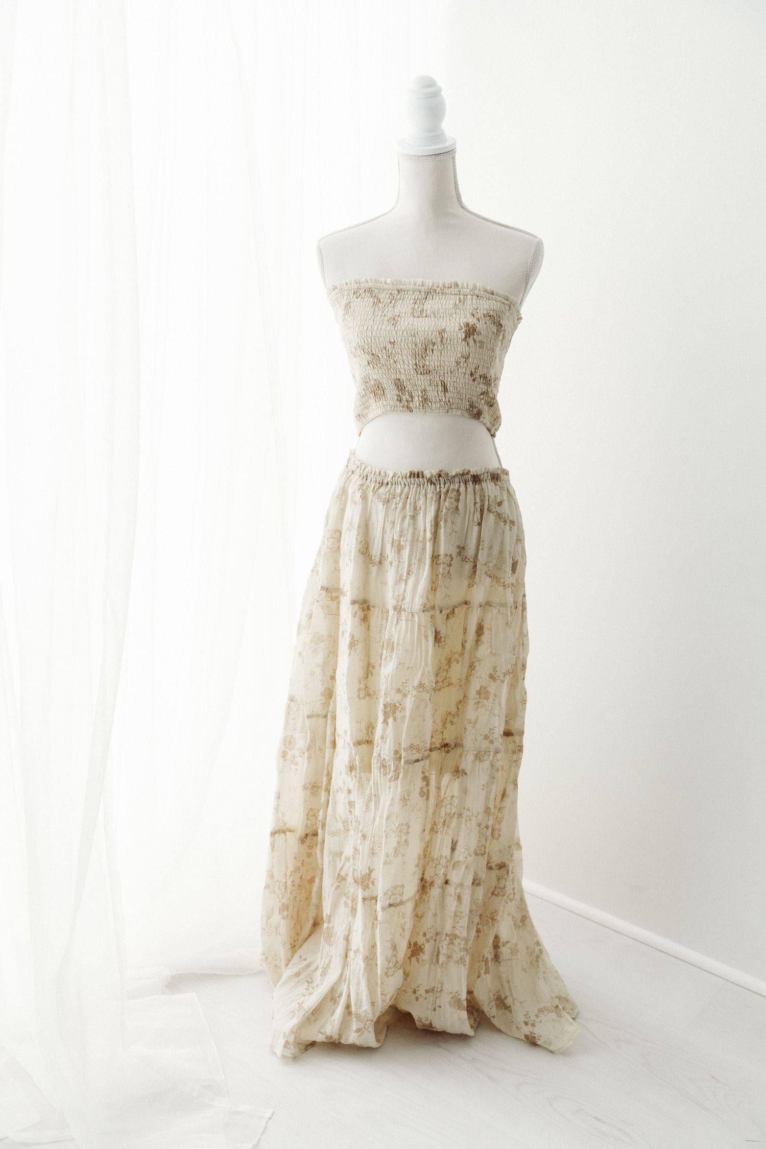 Beige floral print strapless crop top and tiered maxi skirt set on mannequin.