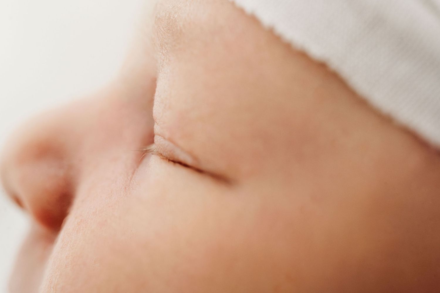 Extreme close-up of a peaceful sleeping newborns face with soft skin and tiny features.