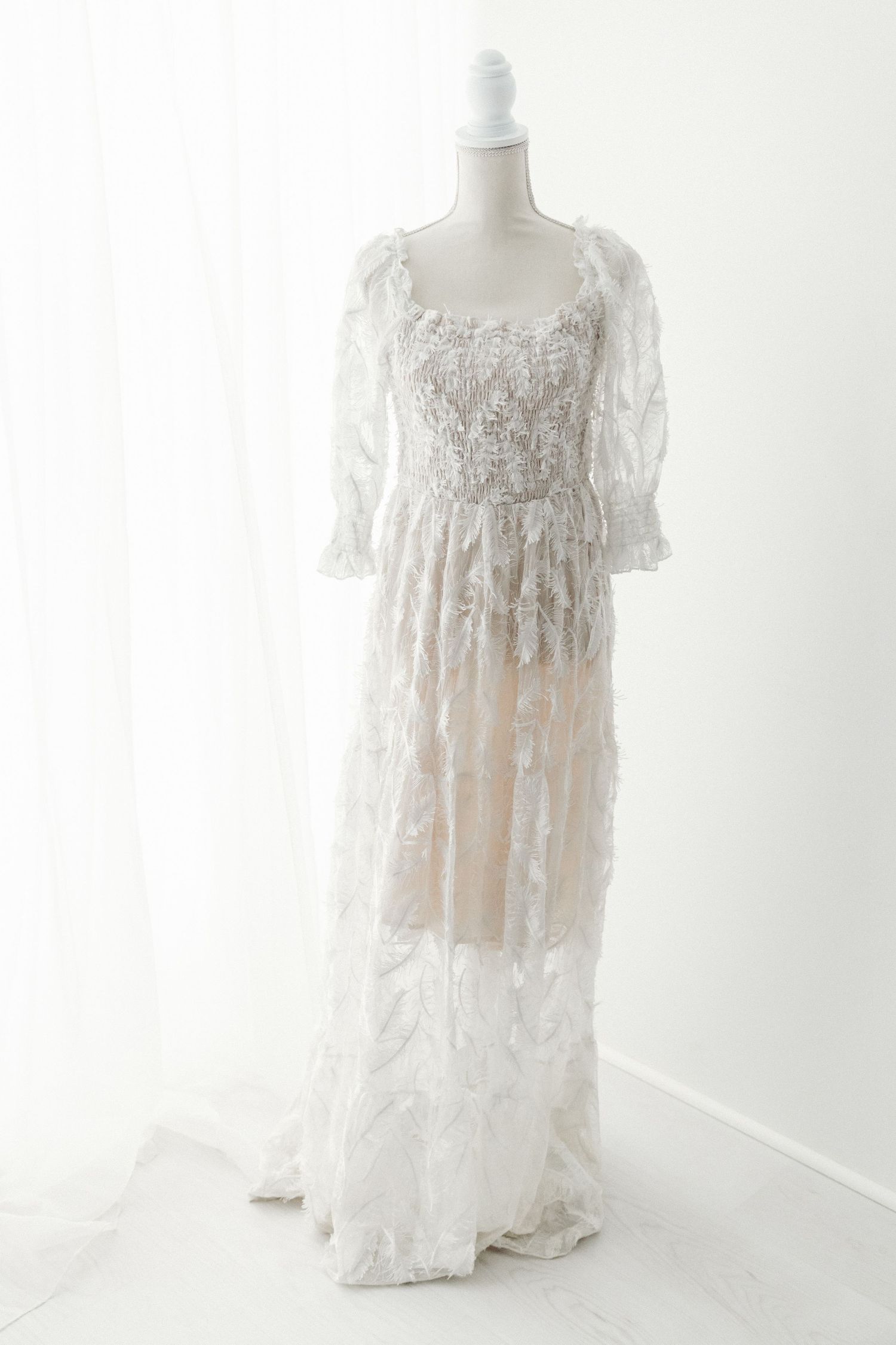 White lace embroidered puff sleeve sheer overlay maxi dress on mannequin.